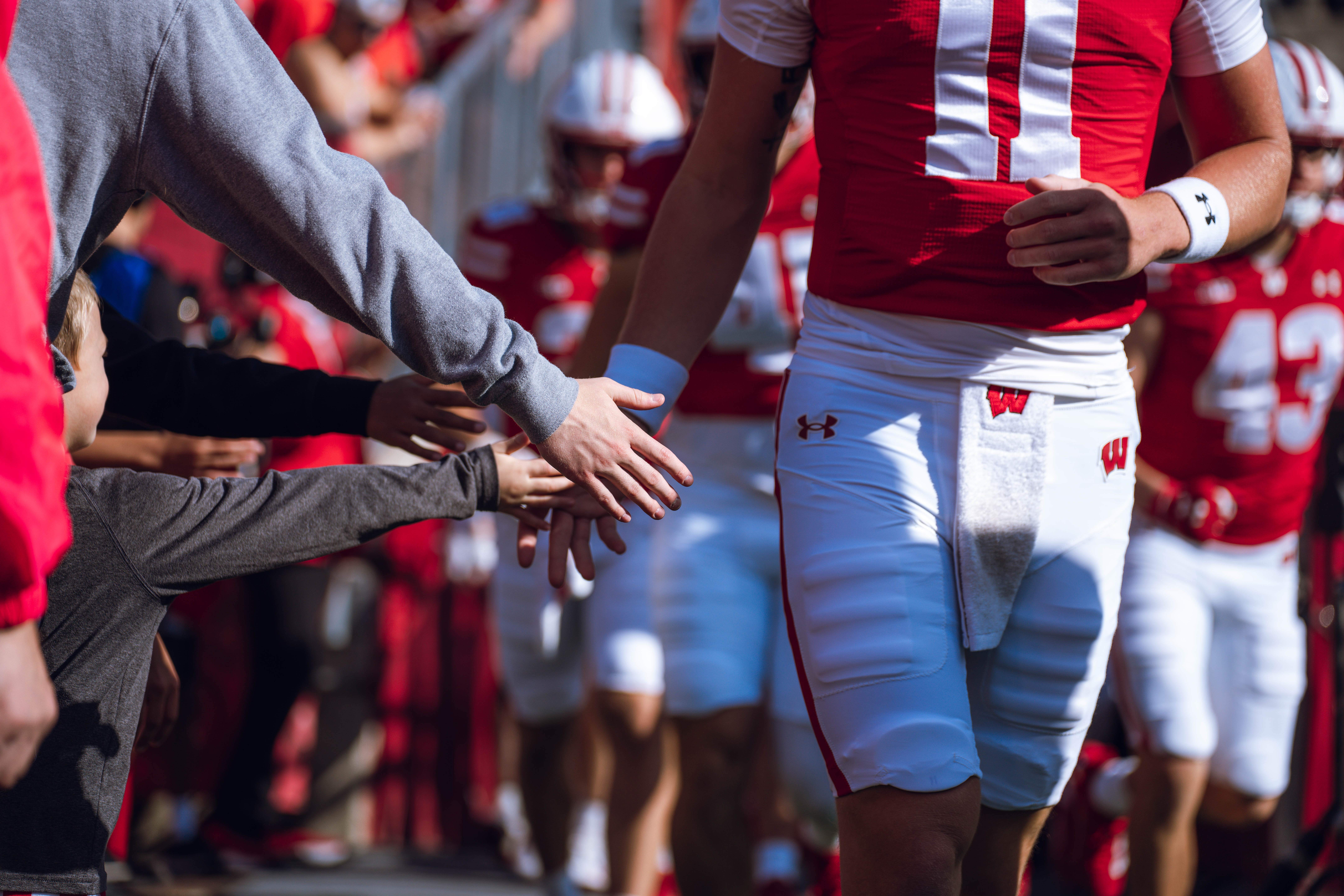 Wisconsin Badgers walk out of the tunnel against the Purdue Boilermakers at Camp Randall Stadium on October 5, 2024 in Madison, Wisconsin. Photography by Ross Harried for Second Crop Sports.