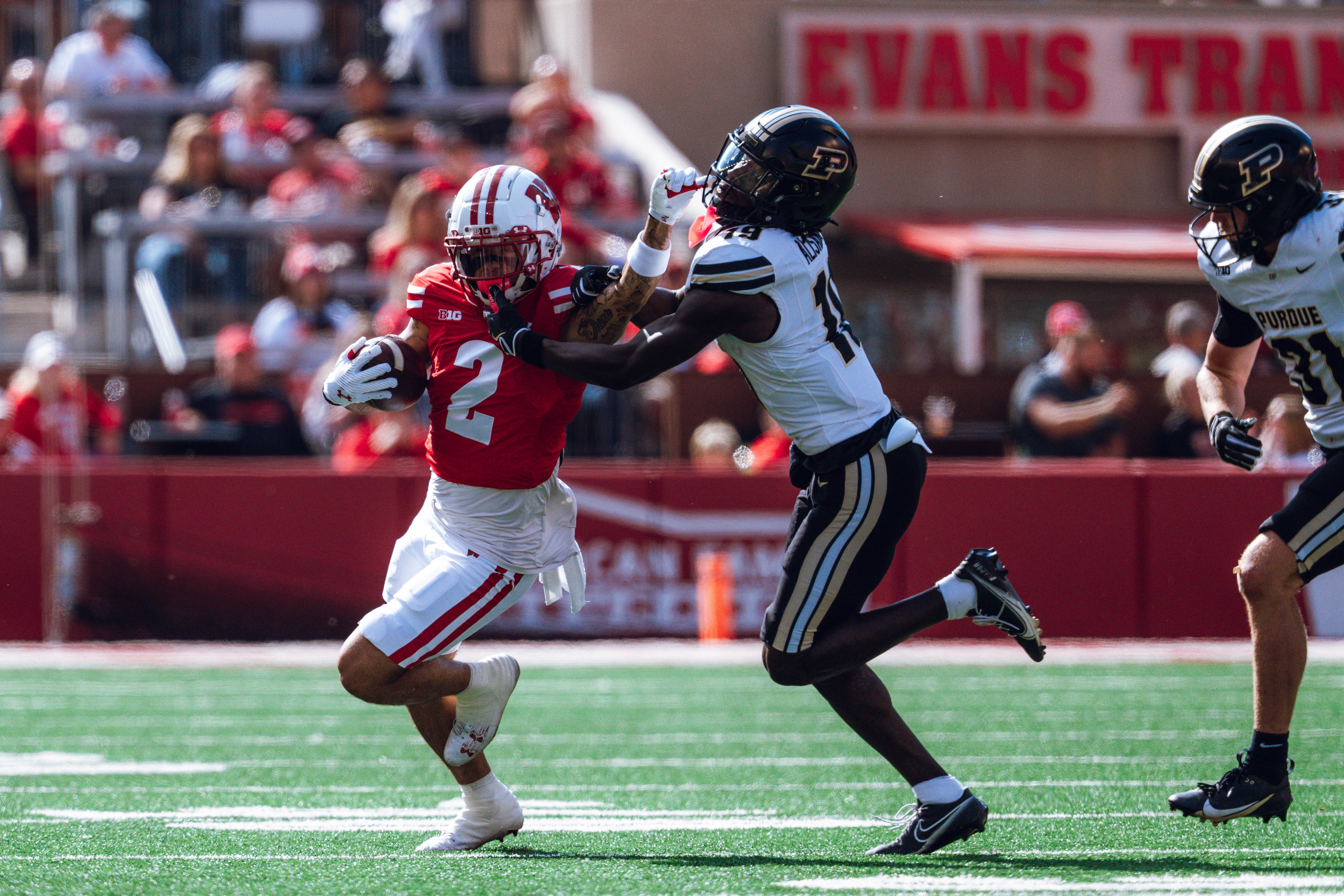 Wisconsin Badgers wide receiver Trech Kekahuna #2 gives a stiff arm to Purdue defensive back Botros Alisandro #19 at Camp Randall Stadium on October 5, 2024 in Madison, Wisconsin. Photography by Ross Harried for Second Crop Sports.