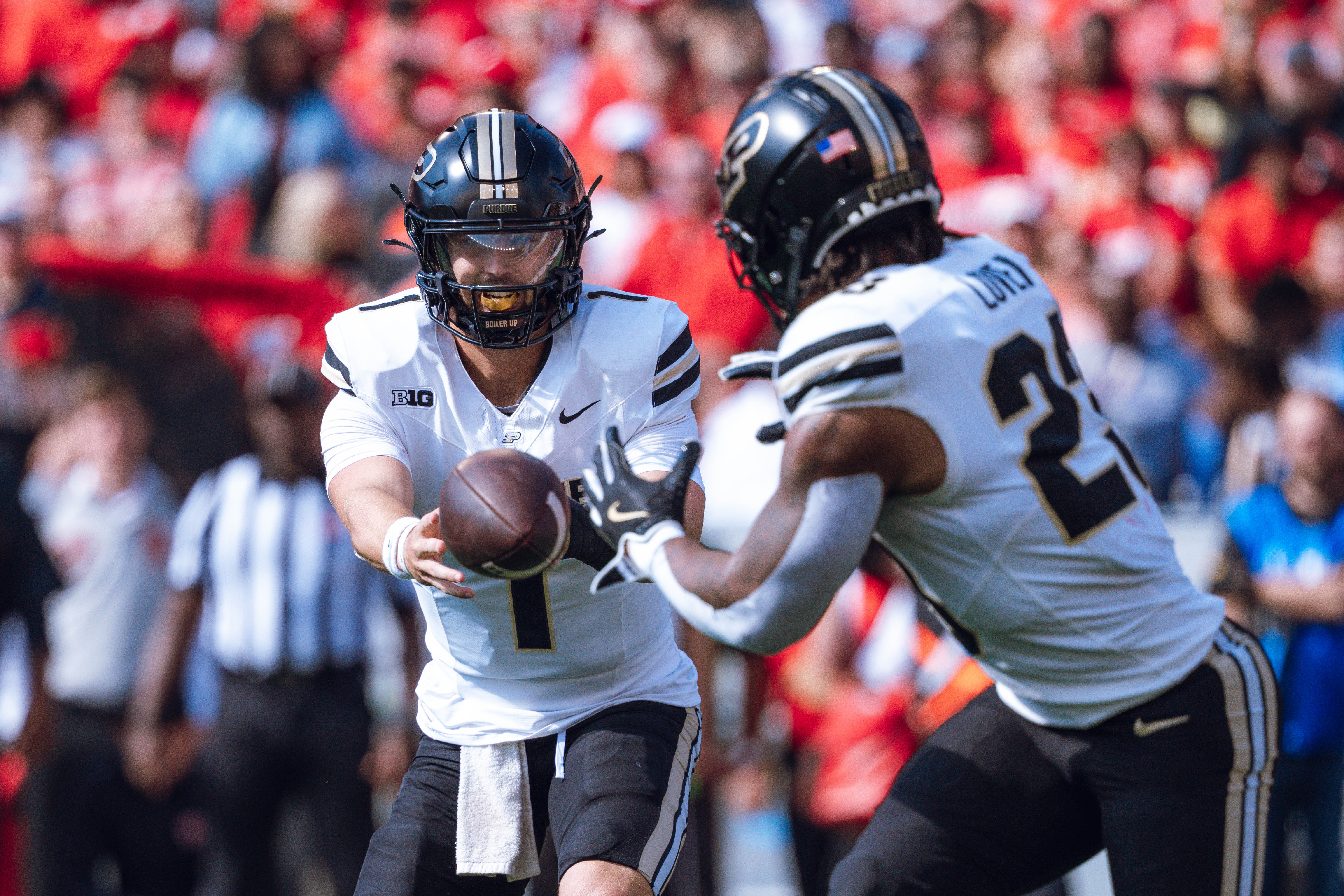 Purdue quarterback Hudson Card #1 pitches the ball to running back Reggie Love III #23 against the Wisconsin Badgers at Camp Randall Stadium on October 5, 2024 in Madison, Wisconsin. Photography by Ross Harried for Second Crop Sports.