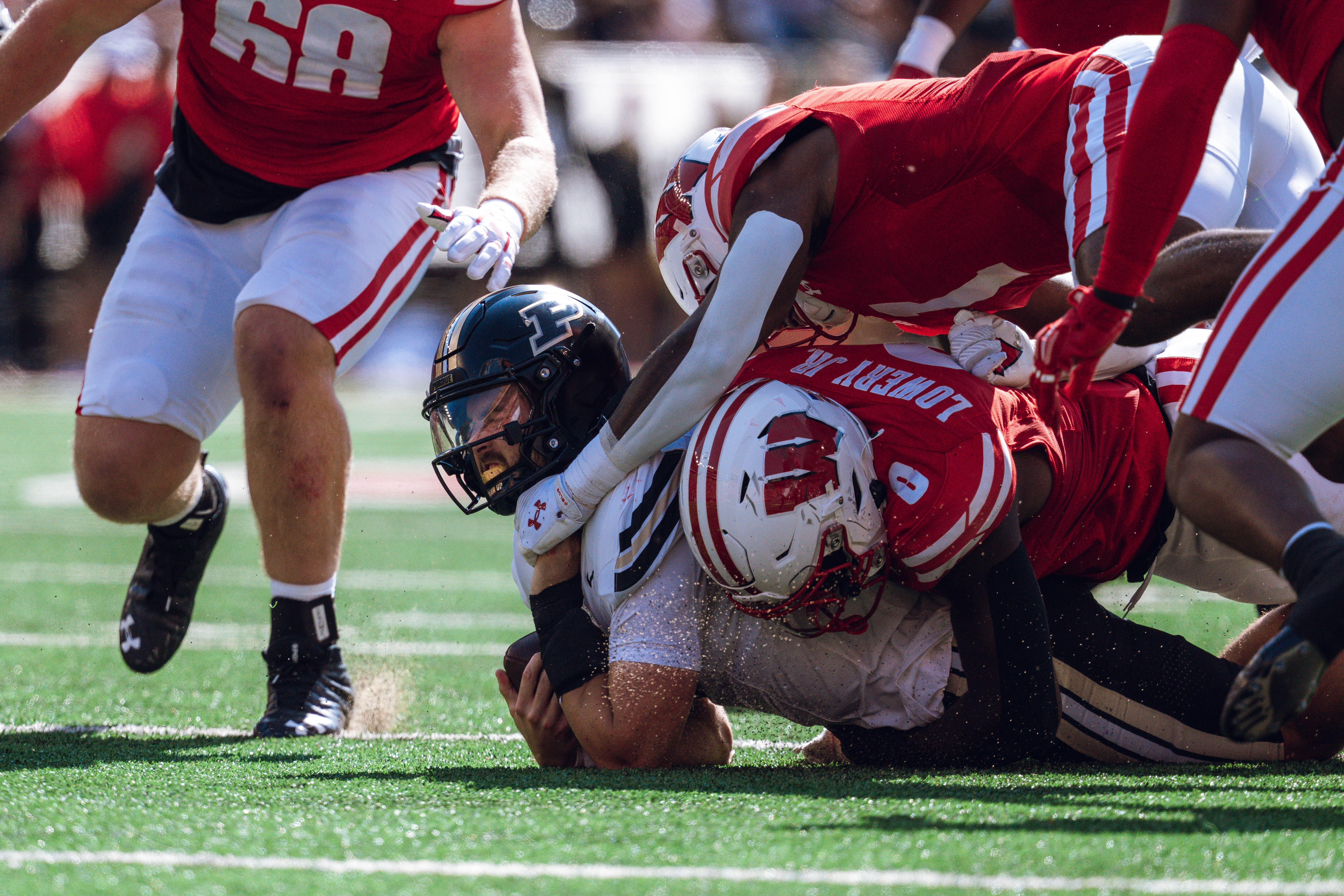 Purdue Boilermaker quarterback Hudson Card #1 is taken down by Wisconsin Badgers outside linebacker John Pius #0 at Camp Randall Stadium on October 5, 2024 in Madison, Wisconsin. Photography by Ross Harried for Second Crop Sports.