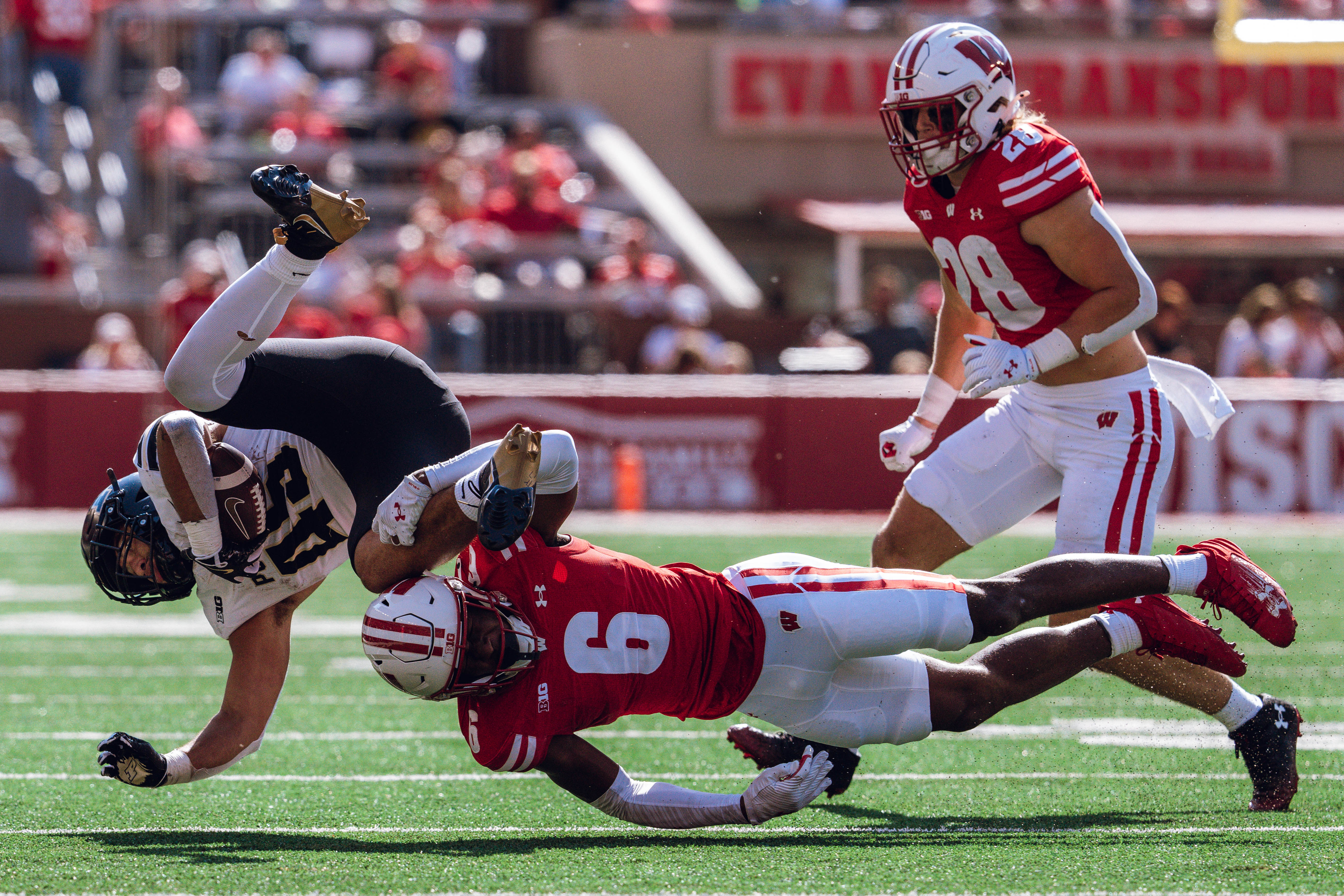 Wisconsin Badgers cornerback Xavier Lucas #6 sends Purdue running back Devin Mockobee #45 airborn at Camp Randall Stadium on October 5, 2024 in Madison, Wisconsin. Photography by Ross Harried for Second Crop Sports.