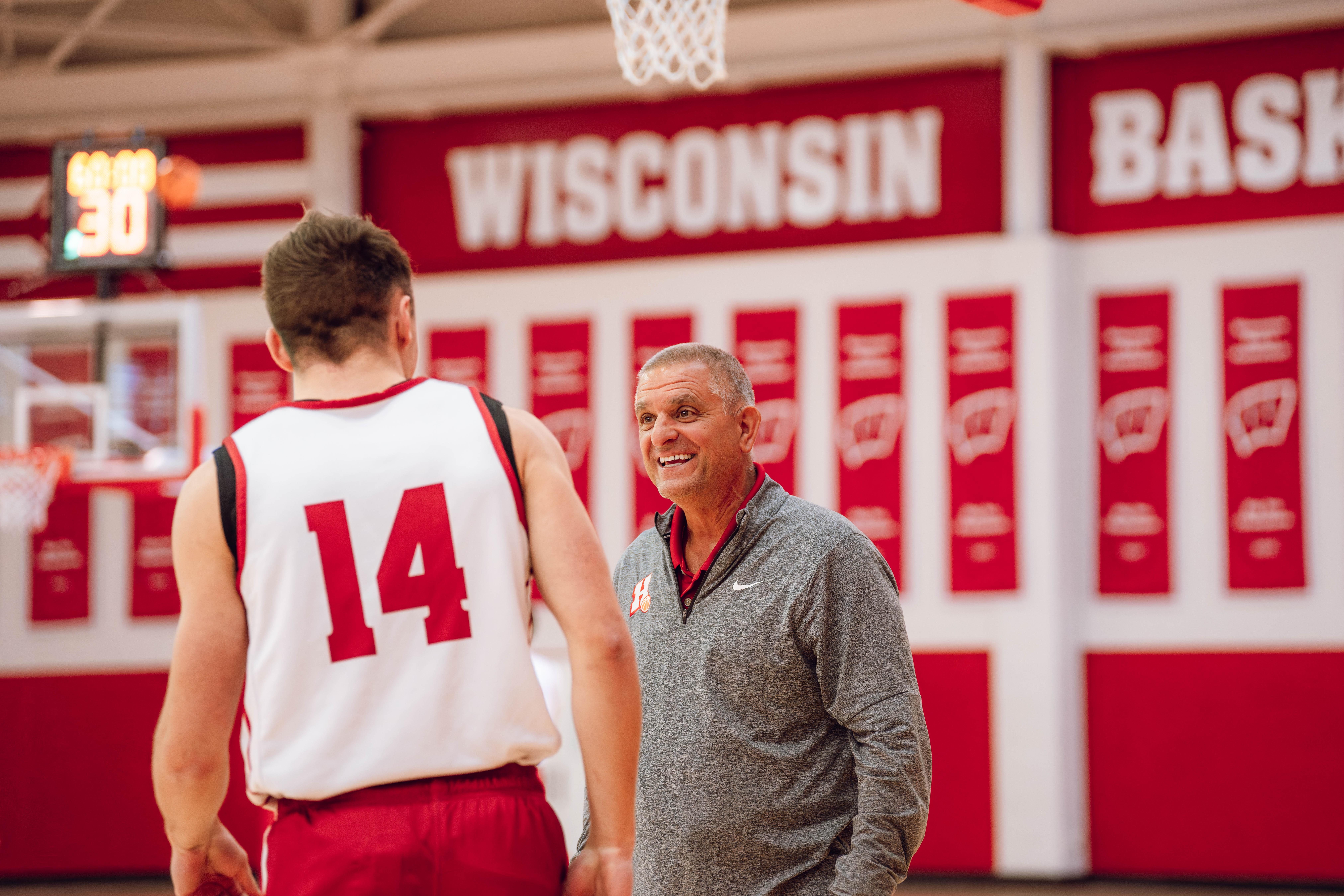 Hamilton High School Boys Basketball Coach Andy Cerroni surprises Wisconsin Badgers guard Aidan Konop #14 during local media day at the Nicholas Johnson Pavilion on October 7, 2024 in Madison, WI. Photography by Ross Harried for Second Crop Sports.