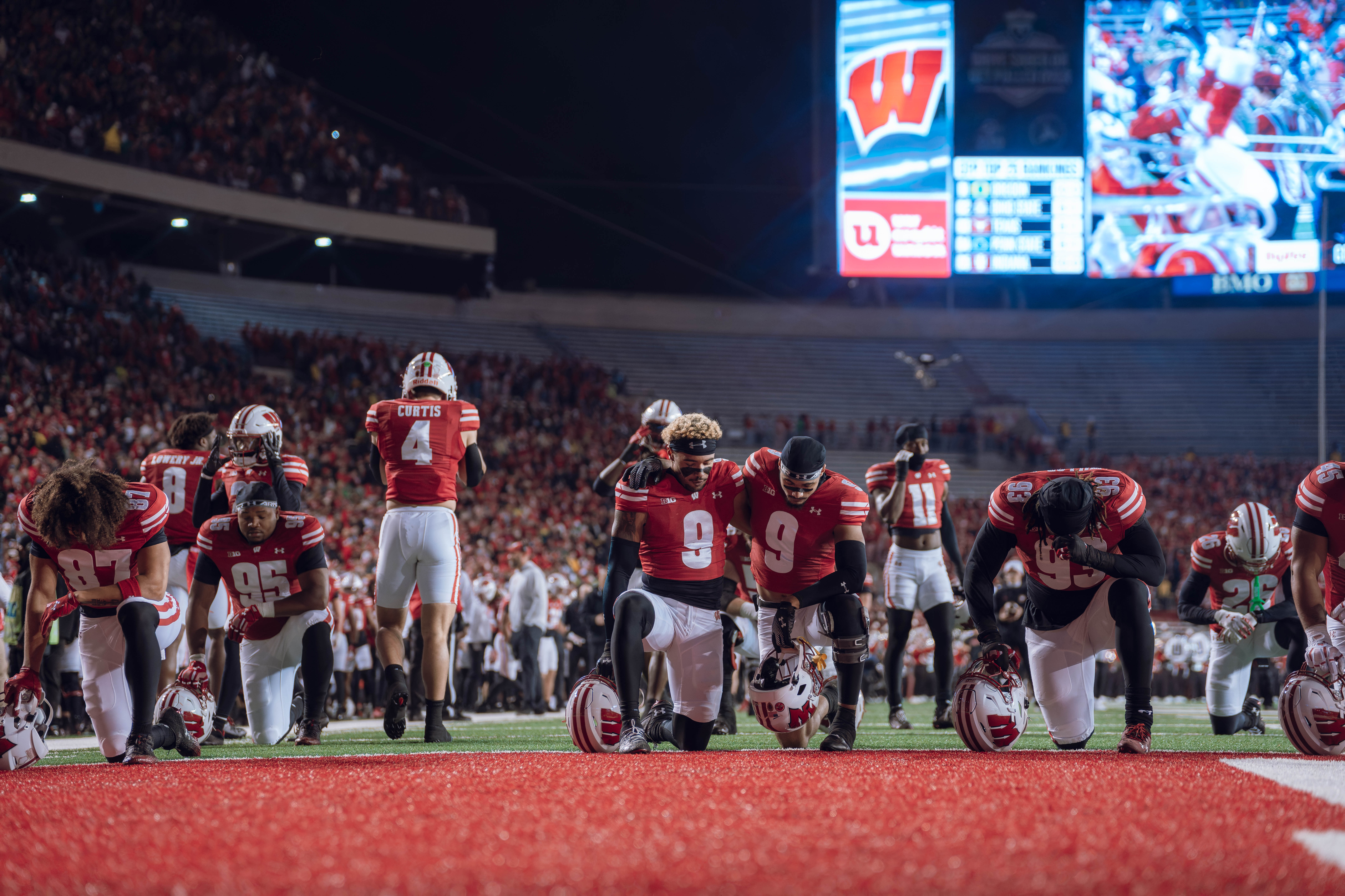 Wisconsin Badgers safety Austin Brown #9 and Wisconsin Badgers wide receiver Bryson Green #9 take a knee prior to kickoff. Wisconsin Badgers vs. Oregon Ducks at Camp Randall Stadium on November 16, 2024 in Madison, Wisconsin. Photography by Ross Harried for Second Crop Sports.