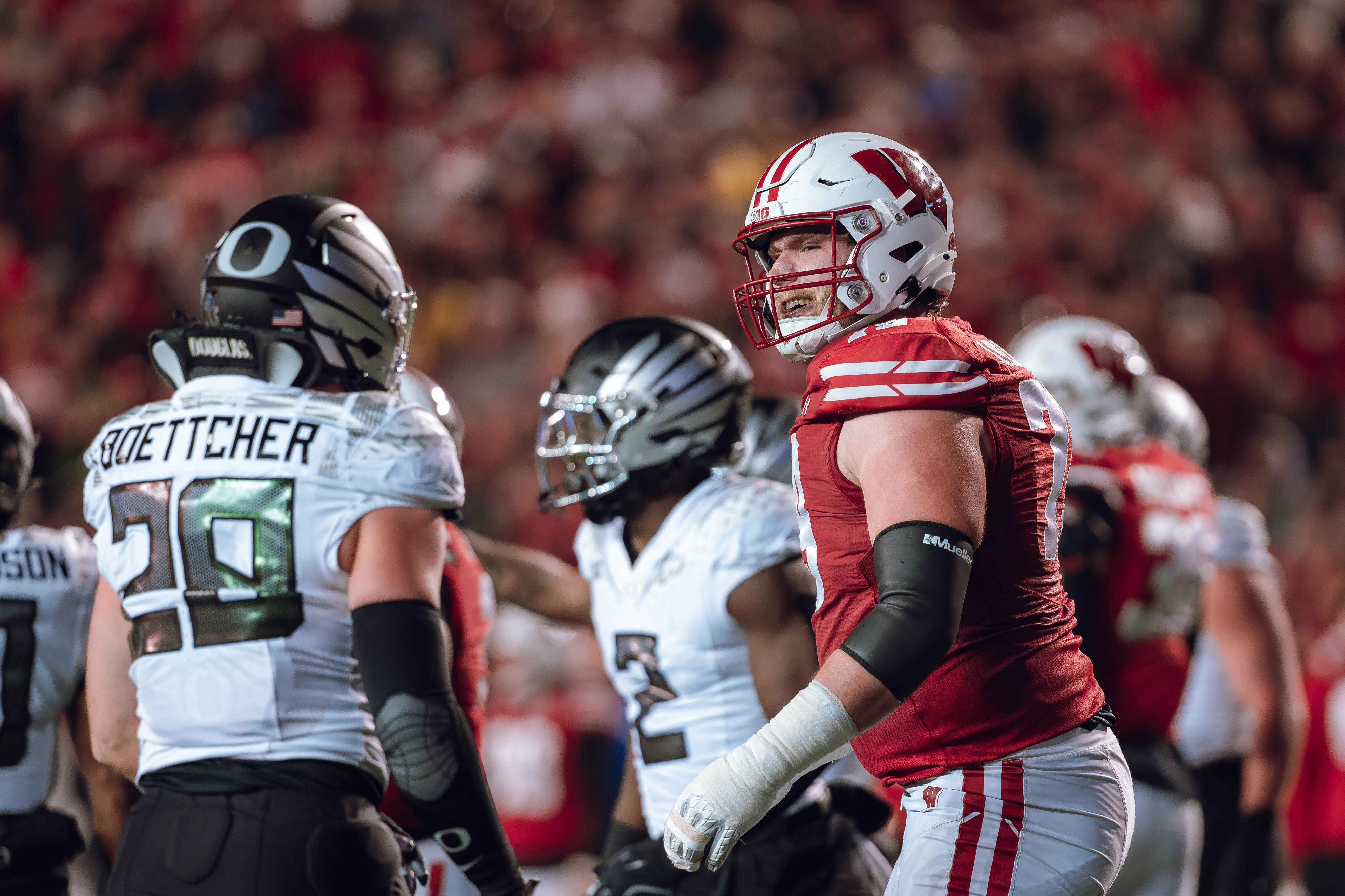 Wisconsin Badgers offensive lineman Jack Nelson #79 gives Oregon inside linebacker Bryce Boettcher #28 a smirk after a play at Camp Randall Stadium on November 16, 2024 in Madison, Wisconsin. Photography by Ross Harried for Second Crop Sports.