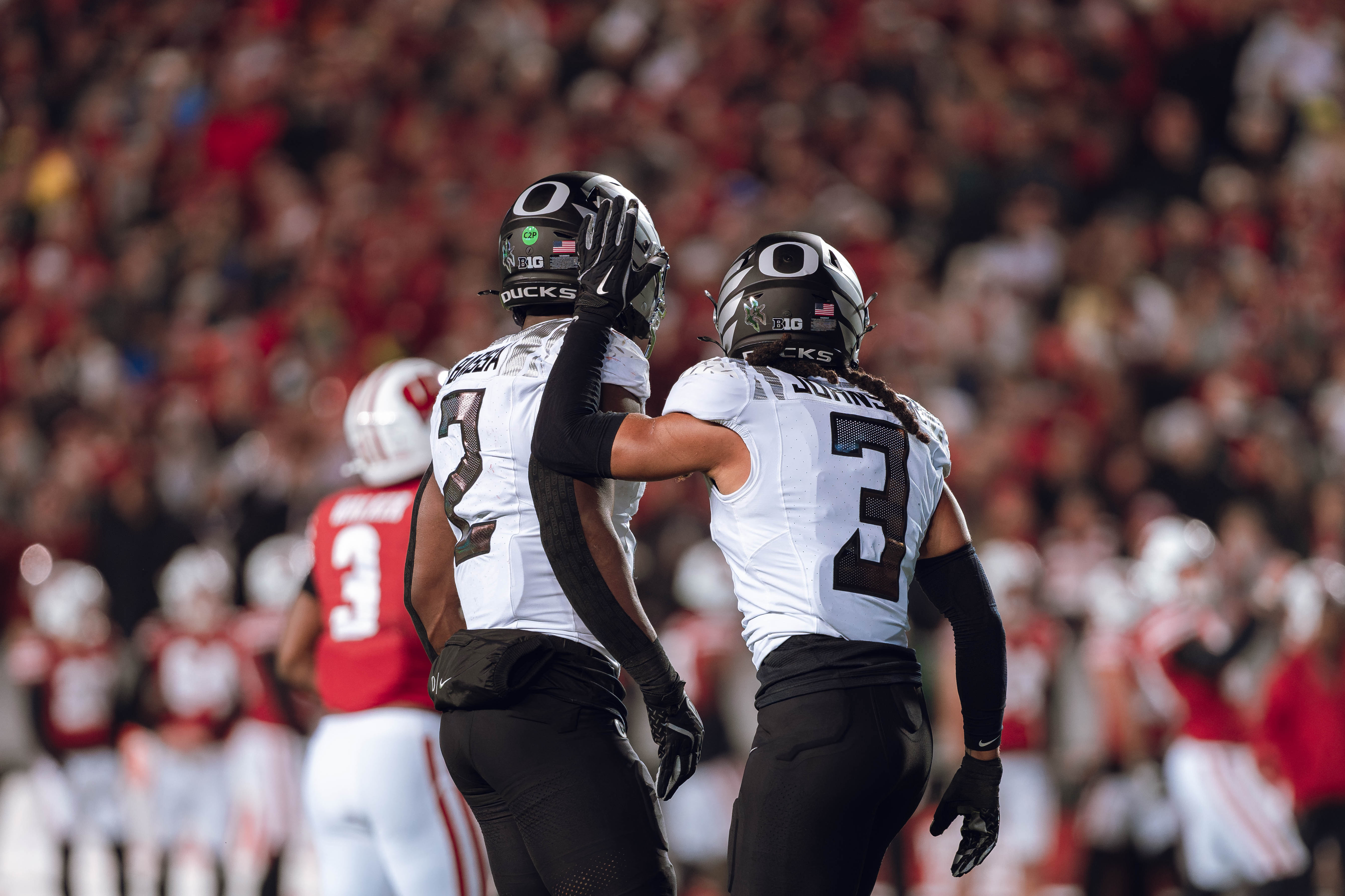 Oregon defensive back Brandon Johnson #3 and Oregon inside linebacker Jeffrey Bassa #2 celebrate after a defensive stop against the Wisconsin Badgers at Camp Randall Stadium on November 16, 2024 in Madison, Wisconsin. Photography by Ross Harried for Second Crop Sports.