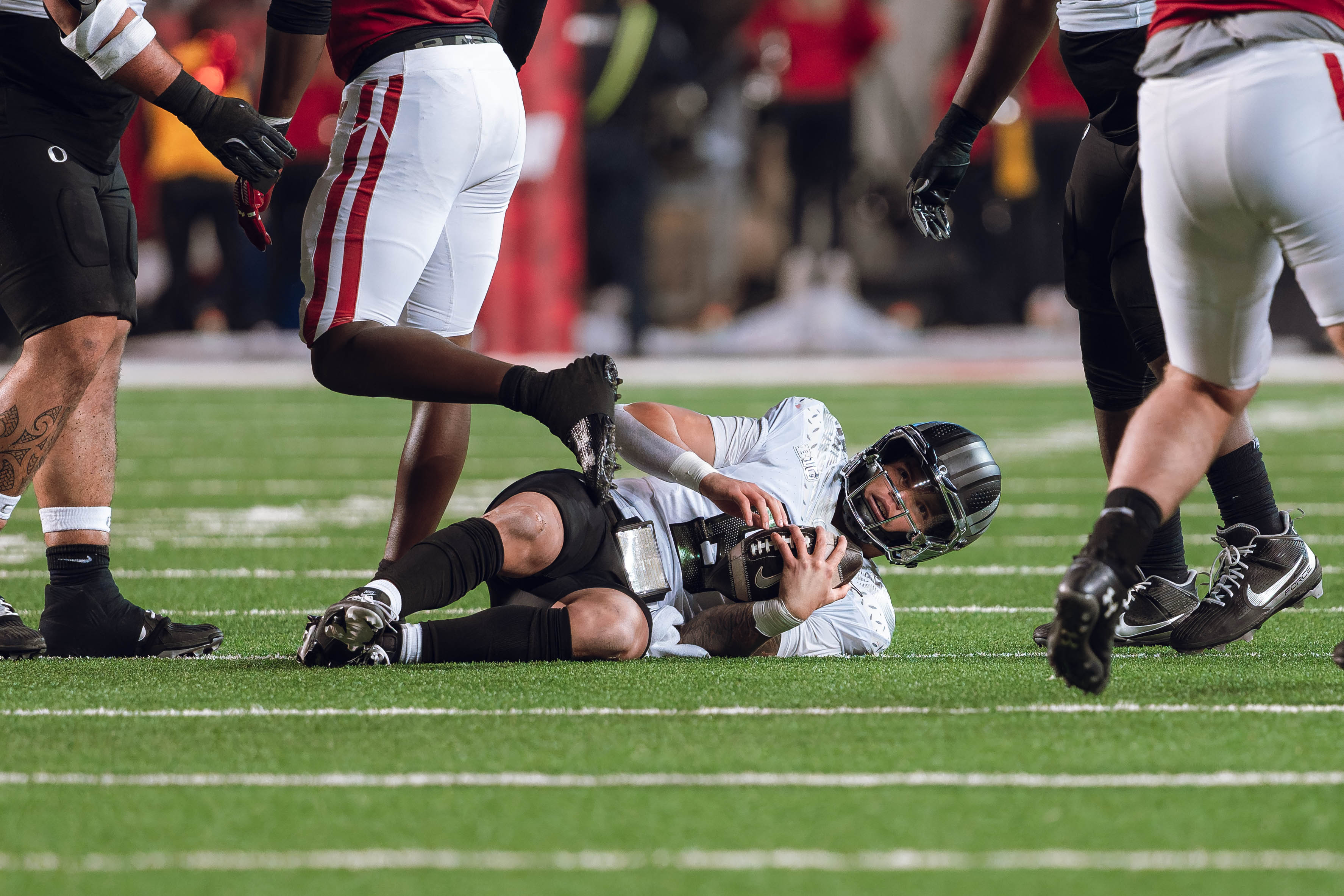 Oregon quarterback Dillon Gabriel #8 lays on the ground after being stopped by the Wisconsin Badgers defense at Camp Randall Stadium on November 16, 2024 in Madison, Wisconsin. Photography by Ross Harried for Second Crop Sports.