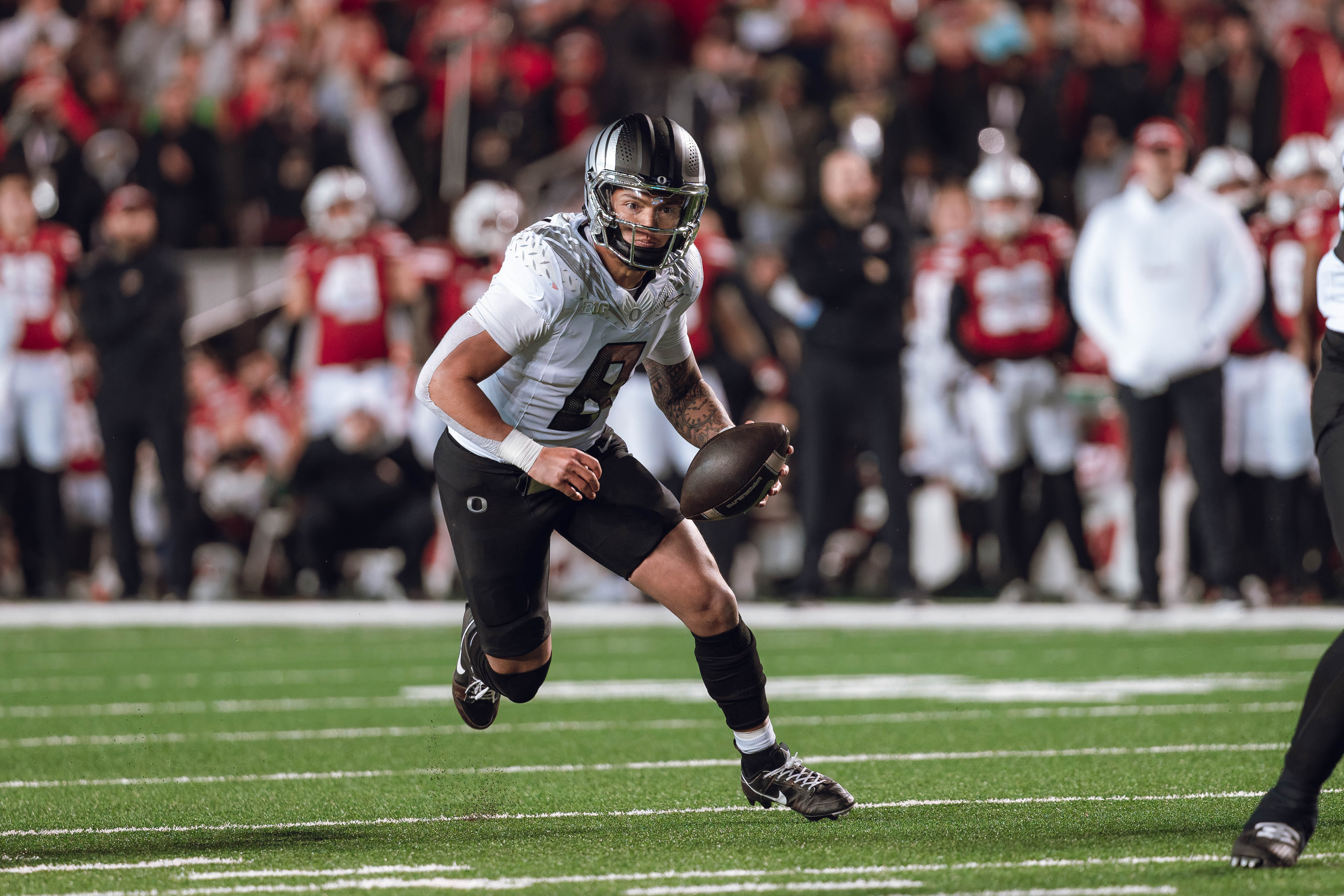 Oregon quarterback Dillon Gabriel #8 scrambles against the Wisconsin Badgers at Camp Randall Stadium on November 16, 2024 in Madison, Wisconsin. Photography by Ross Harried for Second Crop Sports.