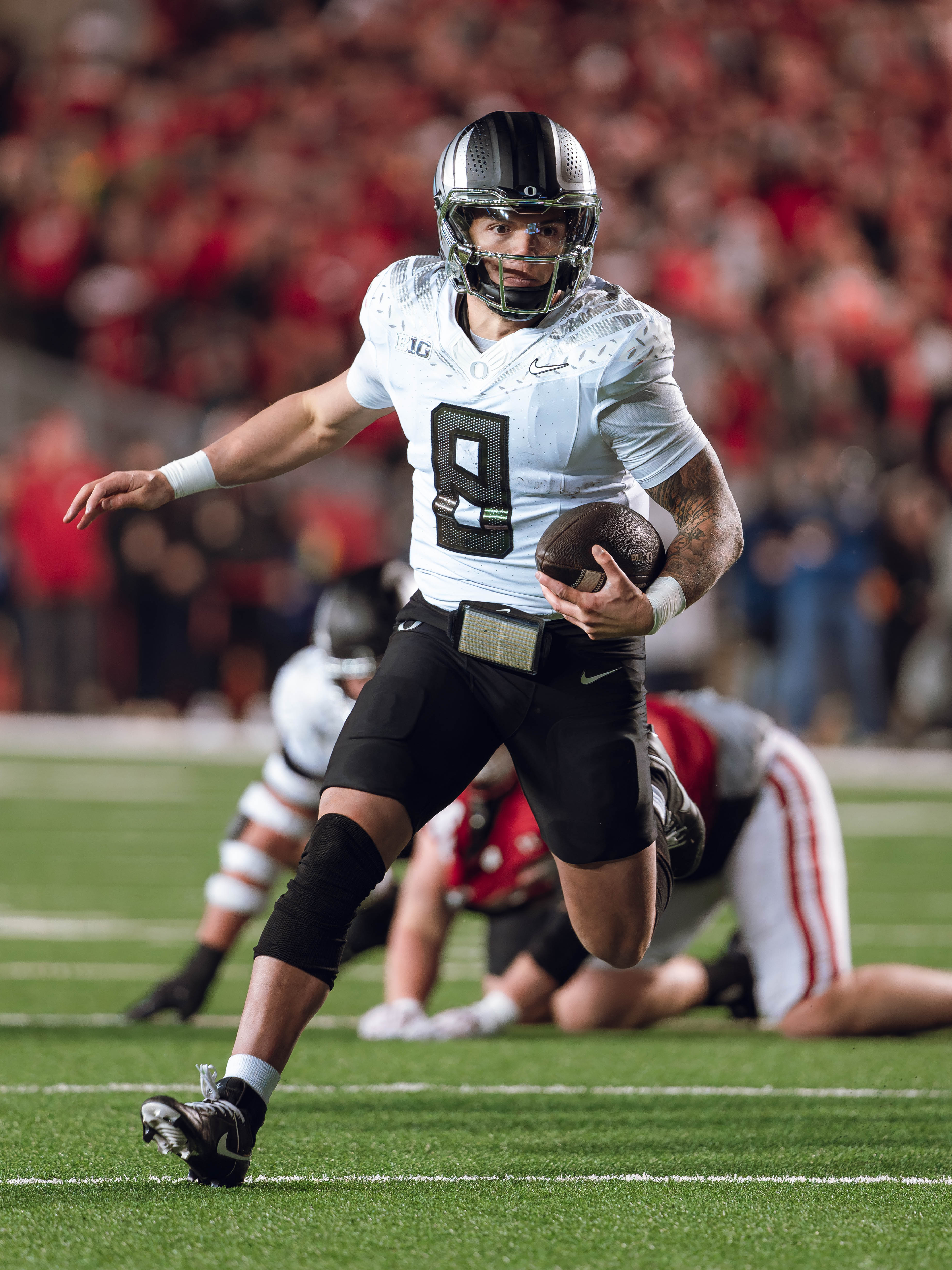 Oregon quarterback Dillon Gabriel #8 scrambles against the Wisconsin Badgers at Camp Randall Stadium on November 16, 2024 in Madison, Wisconsin. Photography by Ross Harried for Second Crop Sports.