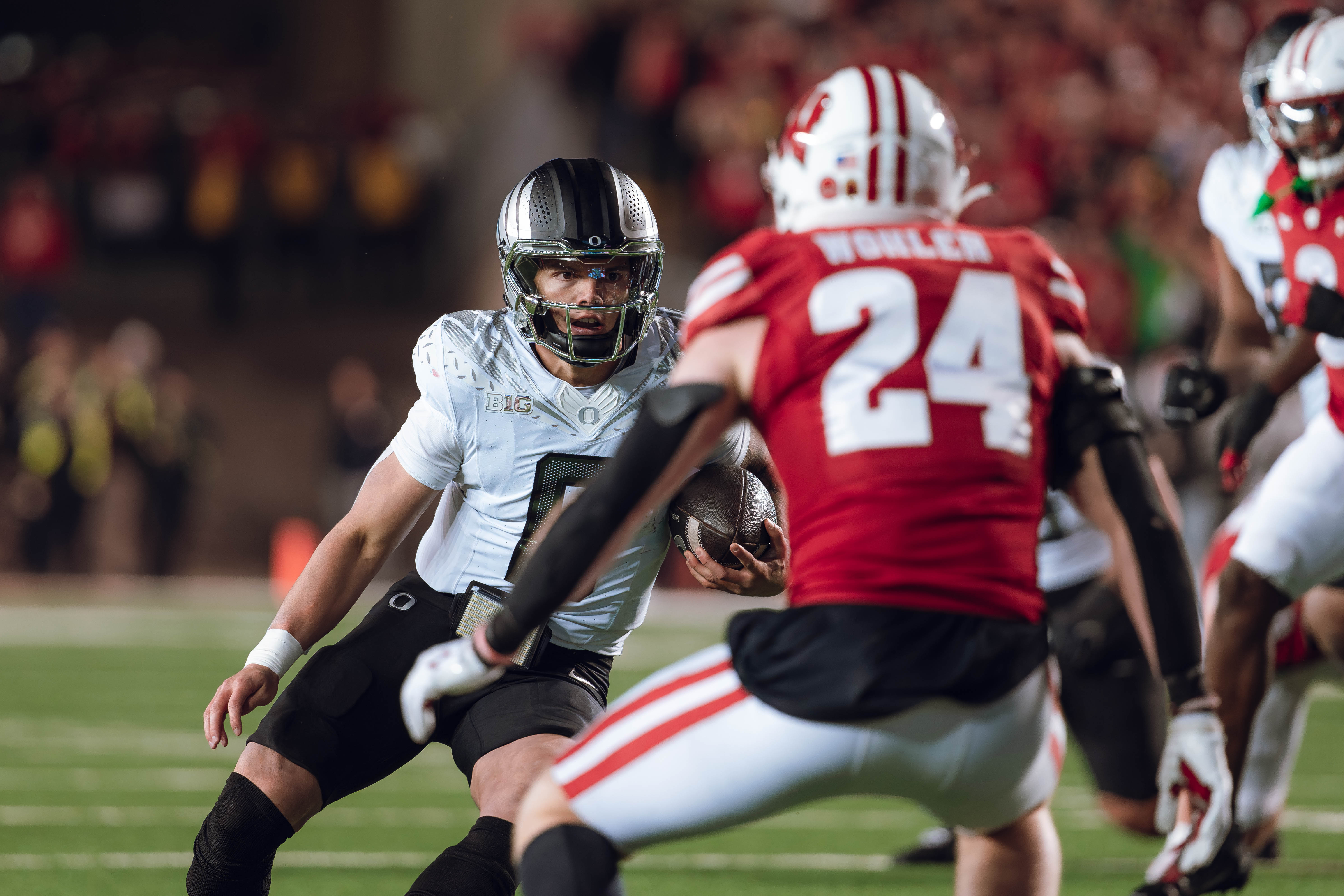 Oregon quarterback Dillon Gabriel #8 scrambles against the Wisconsin Badgers at Camp Randall Stadium on November 16, 2024 in Madison, Wisconsin. Photography by Ross Harried for Second Crop Sports.