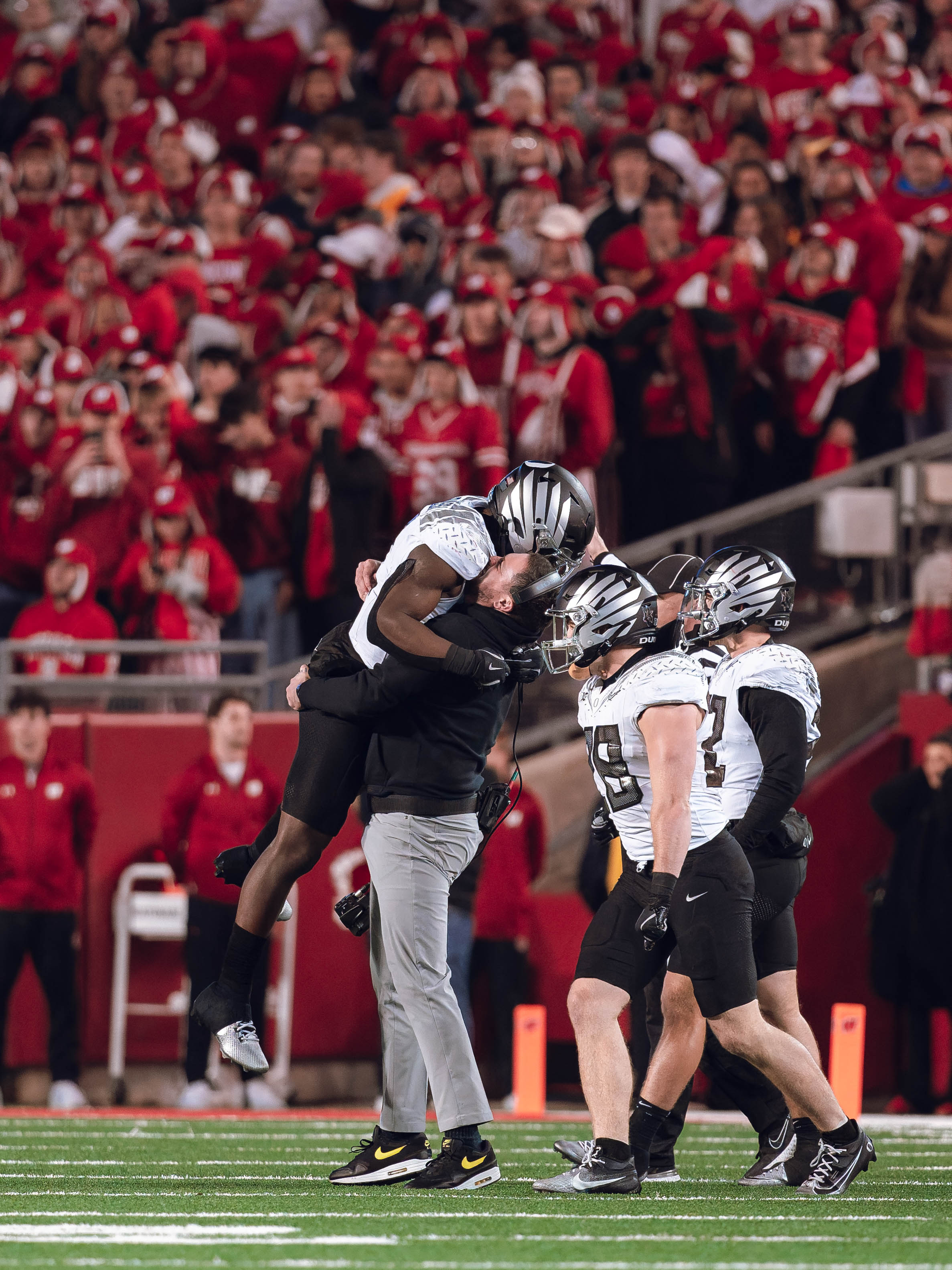 Oregon head coach Dan Lanning celebrates with his team as the Oregon Ducks seal the game with an interception late in the 4th quarter against the Wisconsin Badgers at Camp Randall Stadium on November 16, 2024 in Madison, Wisconsin. Photography by Ross Harried for Second Crop Sports.