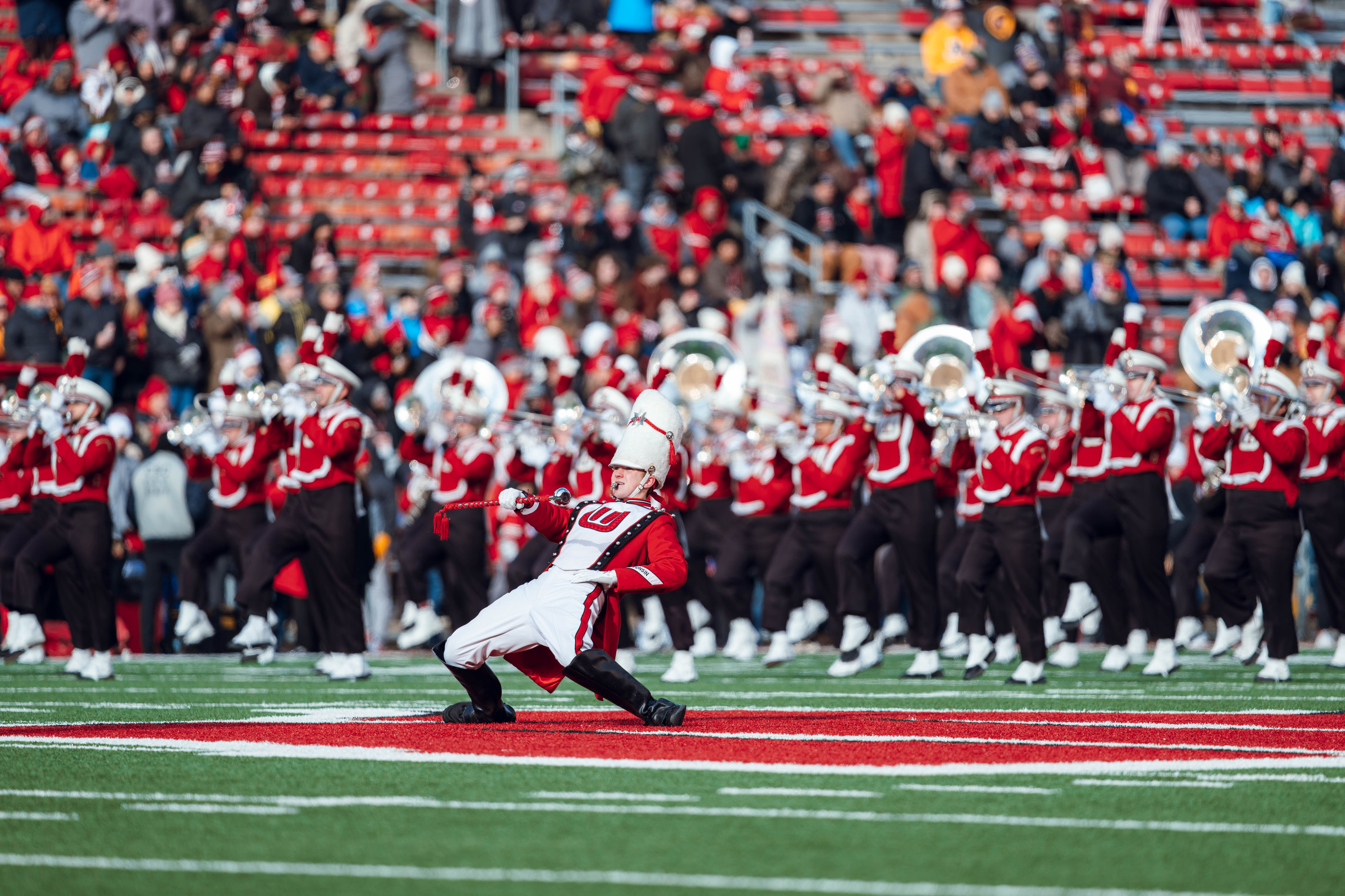 The University of Wisconsin Marching Band Drum Major Caleb Monge leads the band onto the field ahead of the Wisconsin Badgers vs. Minnesota Golden Gophers game at Camp Randall Stadium on November 29, 2024 in Madison, Wisconsin. Photography by Ross Harried for Second Crop Sports.