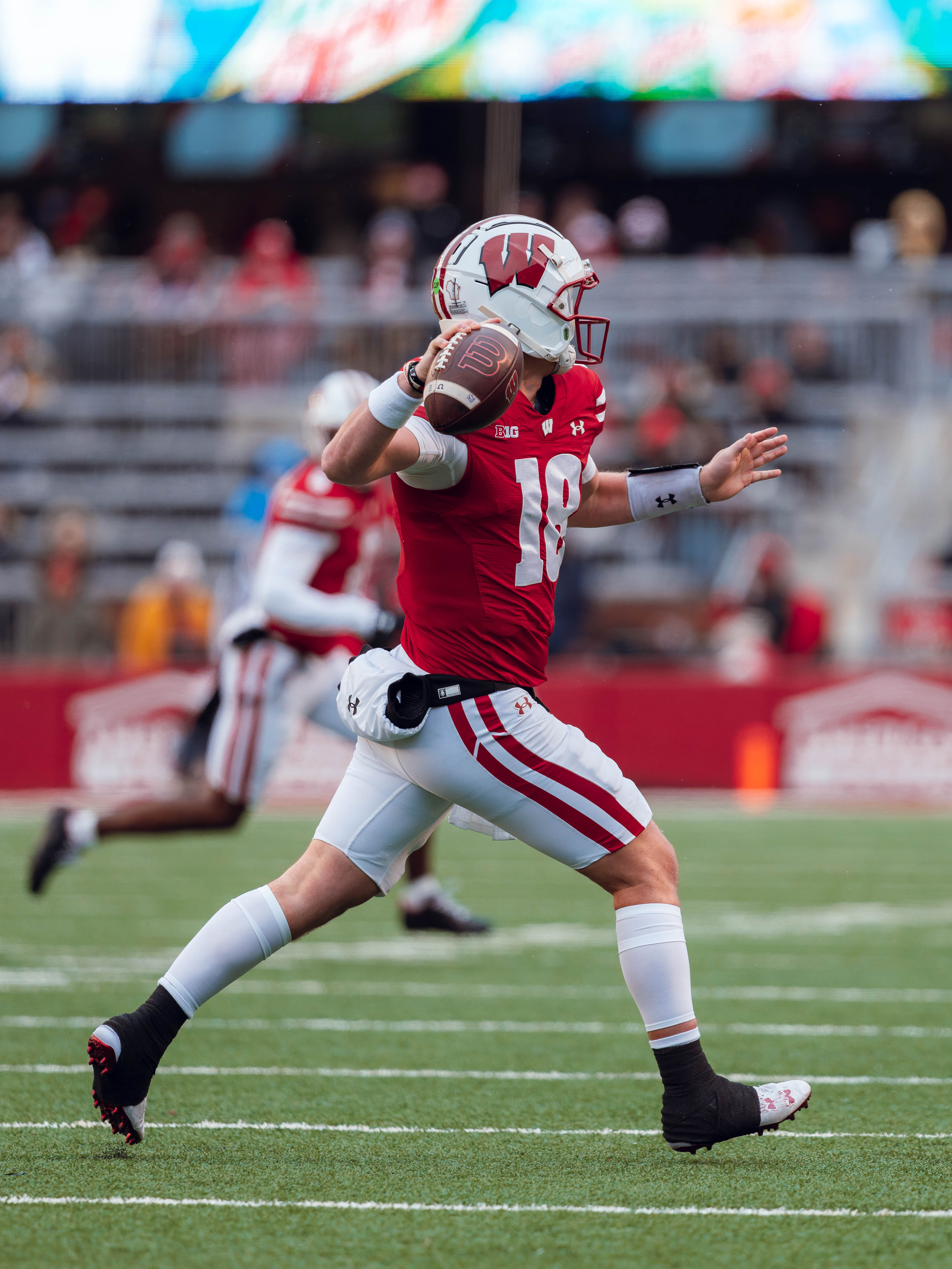 Wisconsin Badgers quarterback Braedyn Locke #18 rolls out of the pocket for a pass against the Minnesota Golden Gophers at Camp Randall Stadium on November 29, 2024 in Madison, Wisconsin. Photography by Ross Harried for Second Crop Sports.