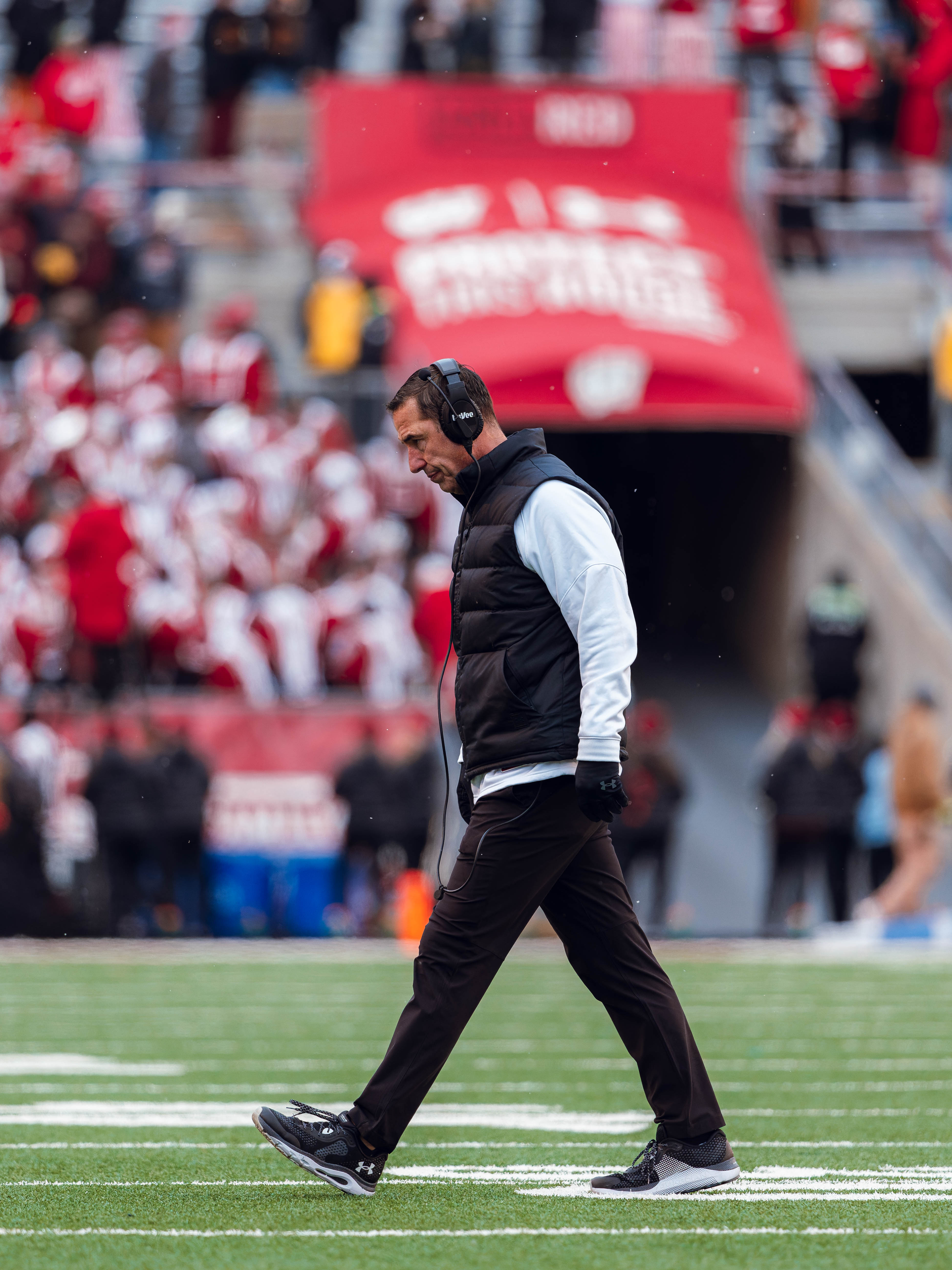 Wisconsin Badgers Head Coach Luke Fickell walks across the field with his head lowered against the Minnesota Golden Gophers at Camp Randall Stadium on November 29, 2024 in Madison, Wisconsin. Photography by Ross Harried for Second Crop Sports.