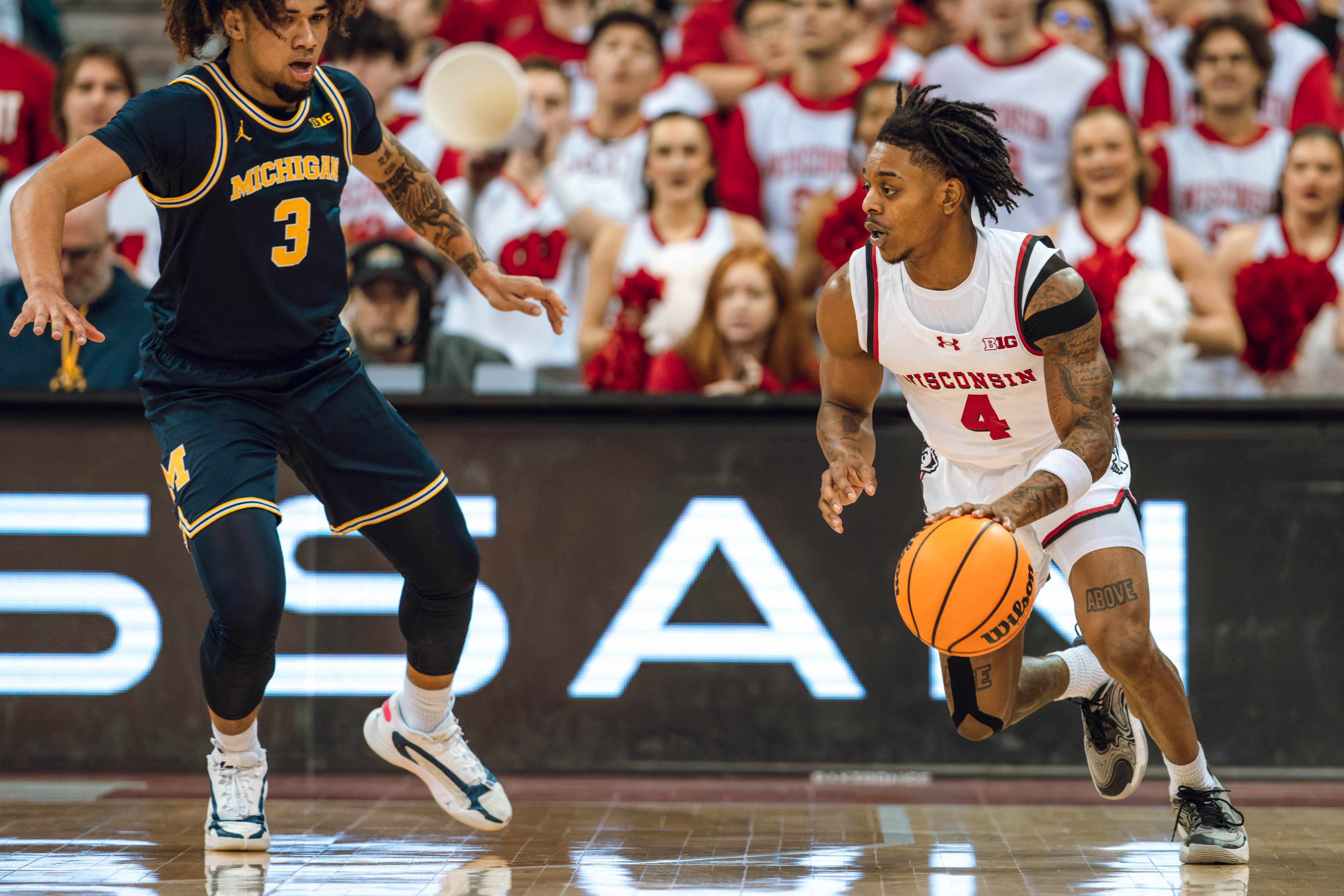 Wisconsin Badgers guard Kamari McGee #4 is defended by Michigan Wolverines guard Tre Donaldson #3 at the Kohl Center on December 03, 2024 in Madison, Wisconsin. Photography by Ross Harried for Second Crop Sports.