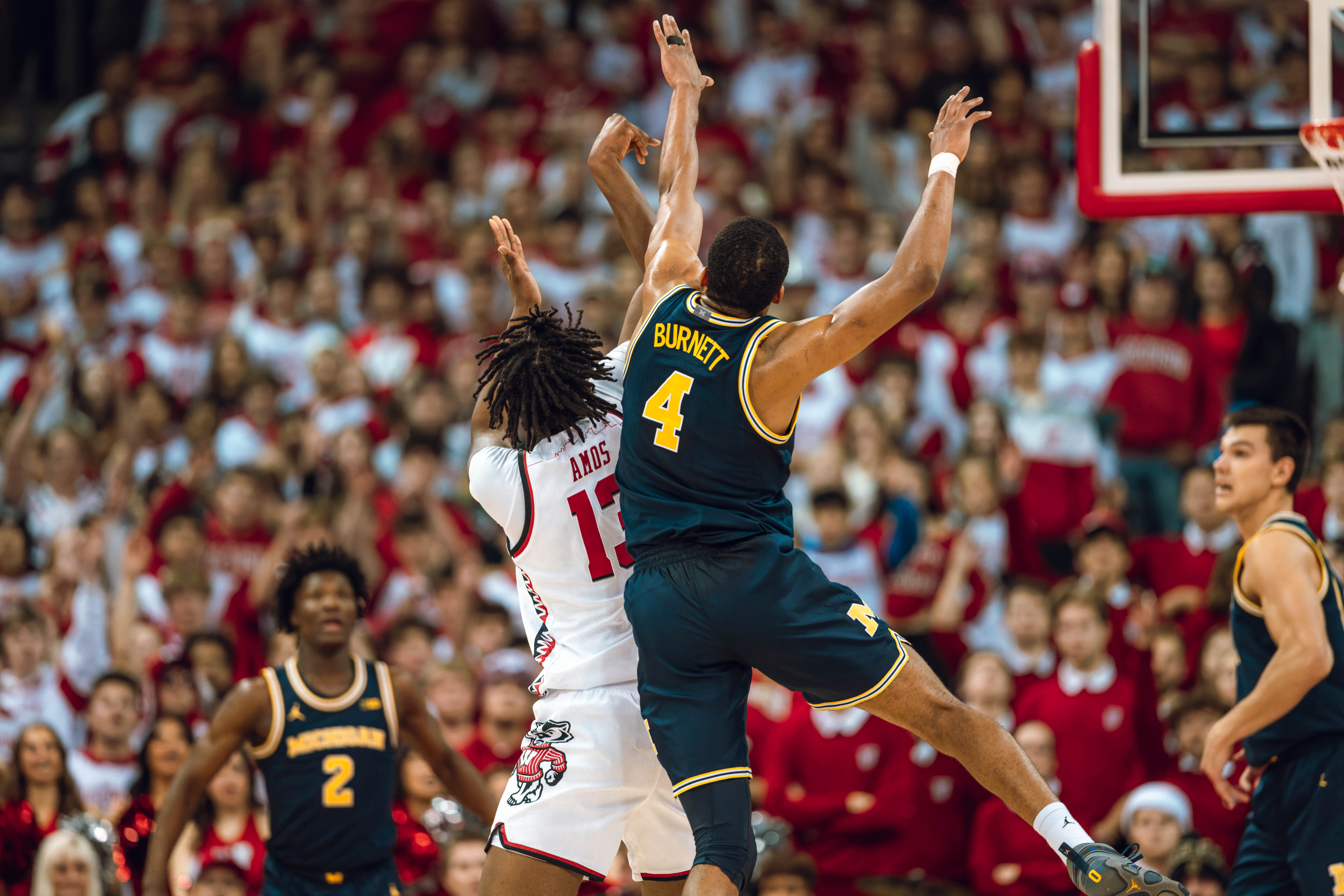 Wisconsin Badgers forward Xavier Amos #13 attempts a shot while being defended by Michigan Wolverines guard Nimari Burnett #4 at the Kohl Center on December 03, 2024 in Madison, Wisconsin. Photography by Ross Harried for Second Crop Sports.