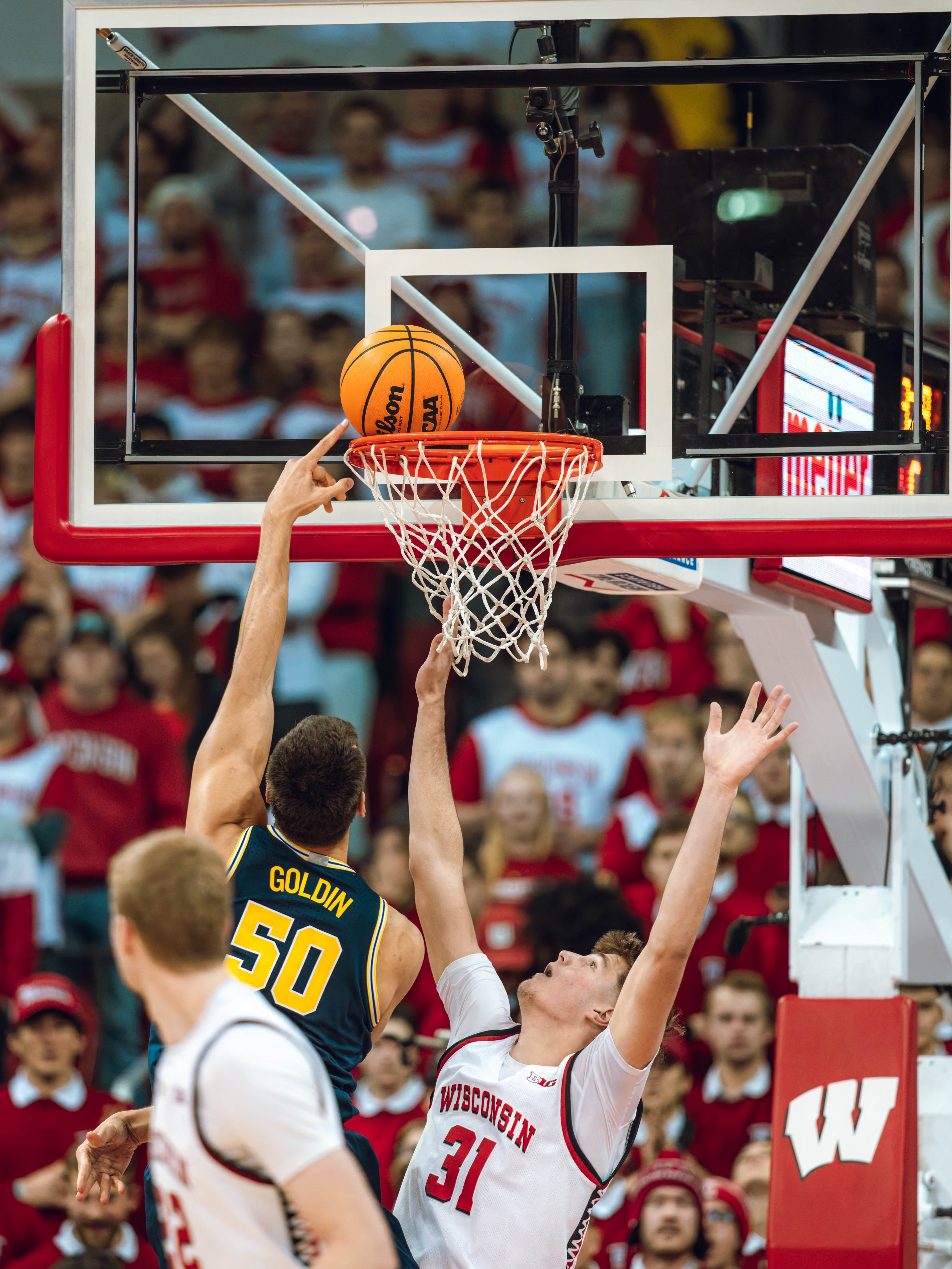 Michigan Wolverines center Vladislav Goldin #50 lays in a gentle basket on Wisconsin Badgers forward Nolan Winter #31 at the Kohl Center on December 03, 2024 in Madison, Wisconsin. Photography by Ross Harried for Second Crop Sports.