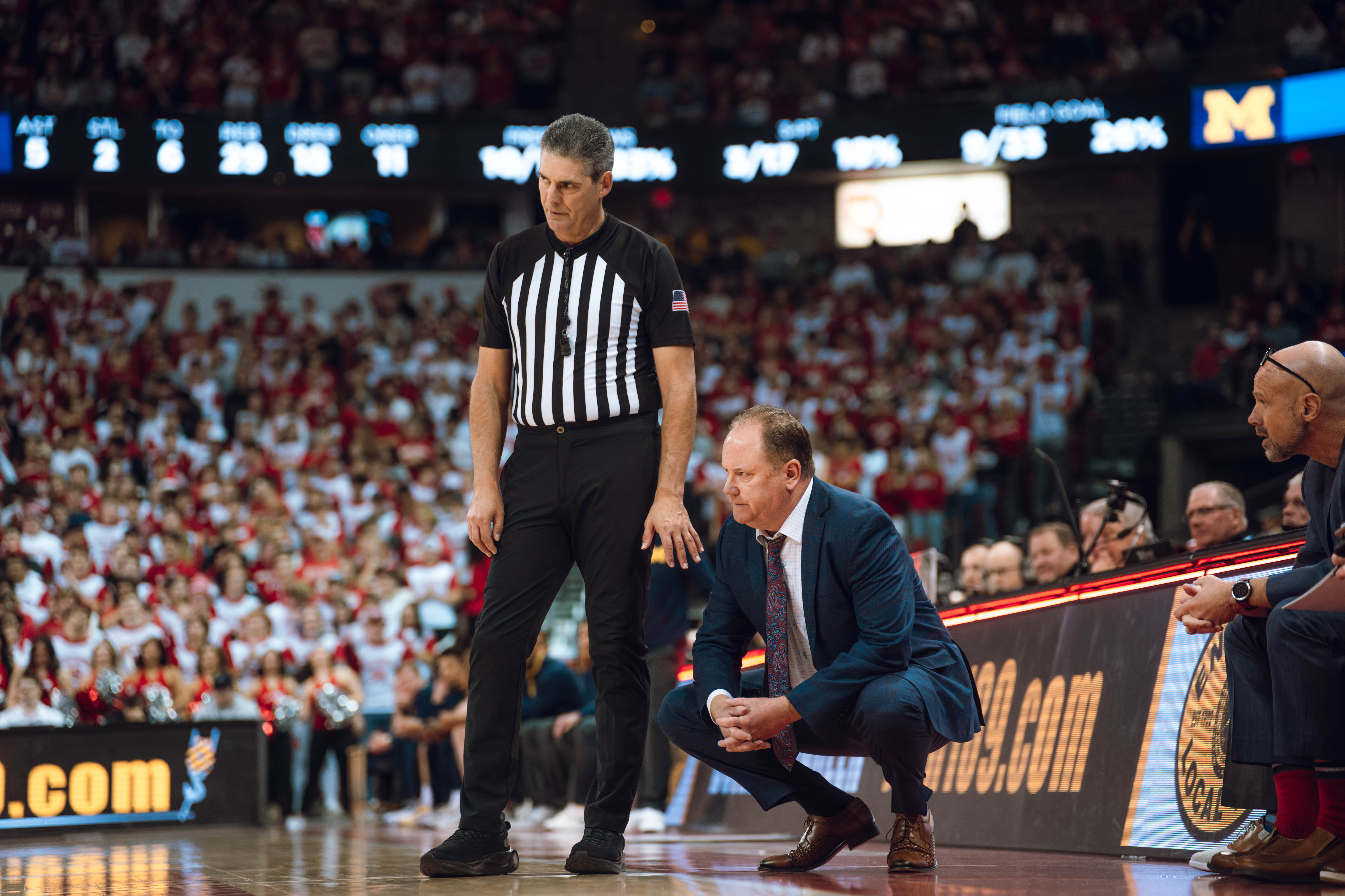 Wisconsin Badgers head coach Greg Gard has a conversation with the referee against the Michigan Wolverines at the Kohl Center on December 03, 2024 in Madison, Wisconsin. Photography by Ross Harried for Second Crop Sports.