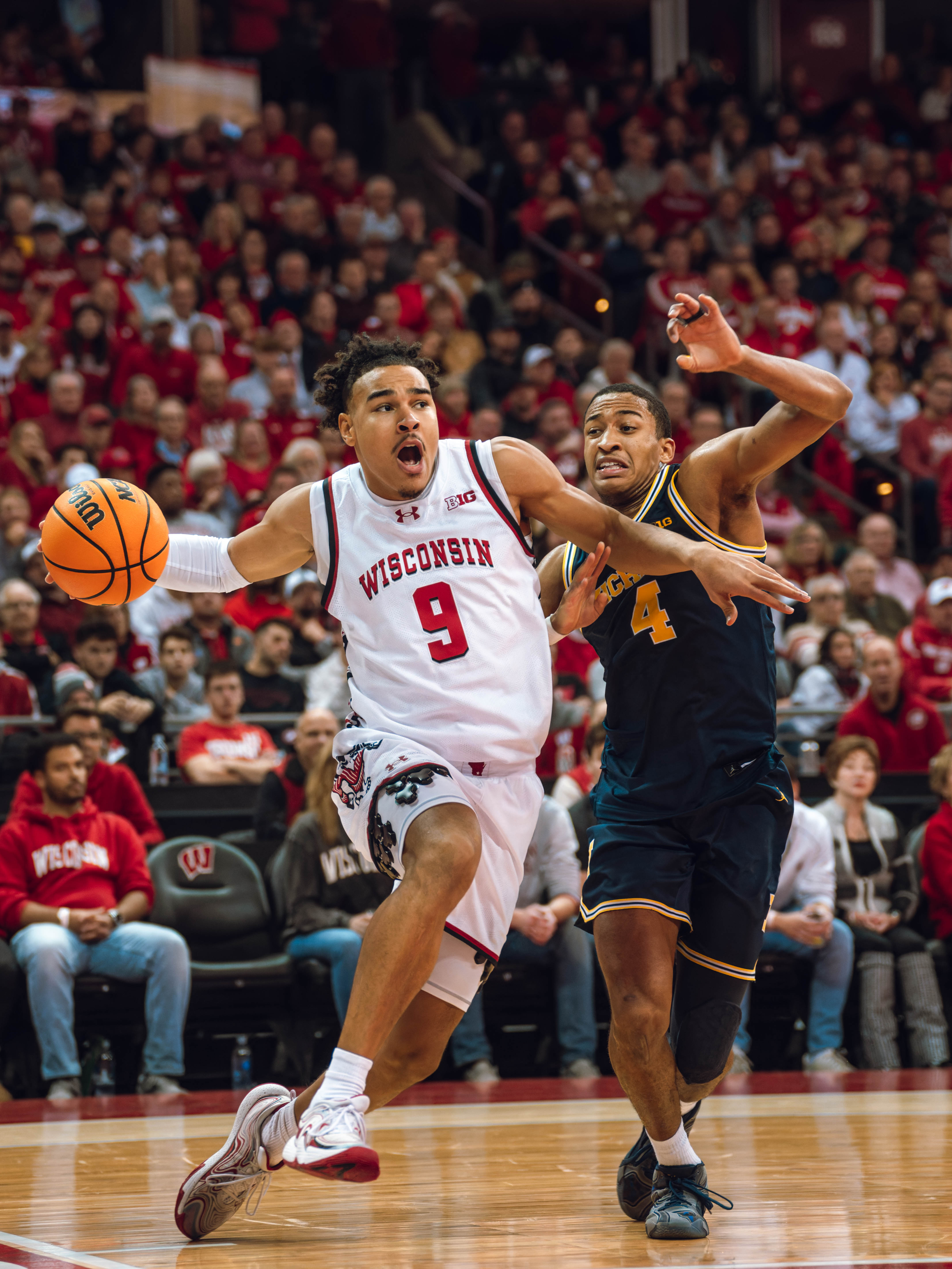 Wisconsin Badgers guard John Tonje #9 drives the baseline against Michigan Wolverines guard Nimari Burnett #4 at the Kohl Center on December 03, 2024 in Madison, Wisconsin. Photography by Ross Harried for Second Crop Sports.