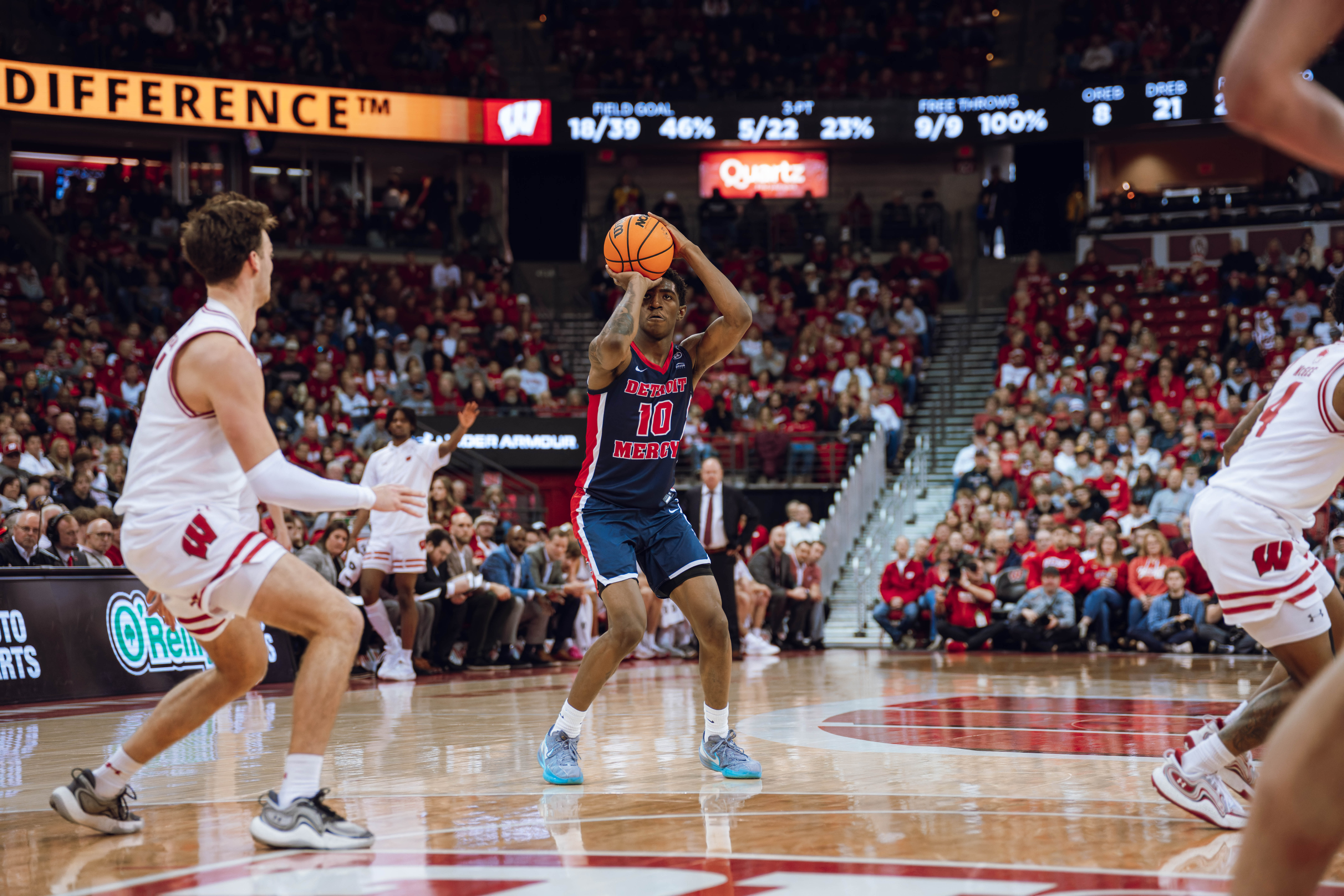 Detroit Mercy Titans guard Nate Johnson #10 pulls up for a jump shot against the Wisconsin Badgers at Kohl Center on December 22, 2024 in Madison, Wisconsin. Photography by Ross Harried for Second Crop Sports.