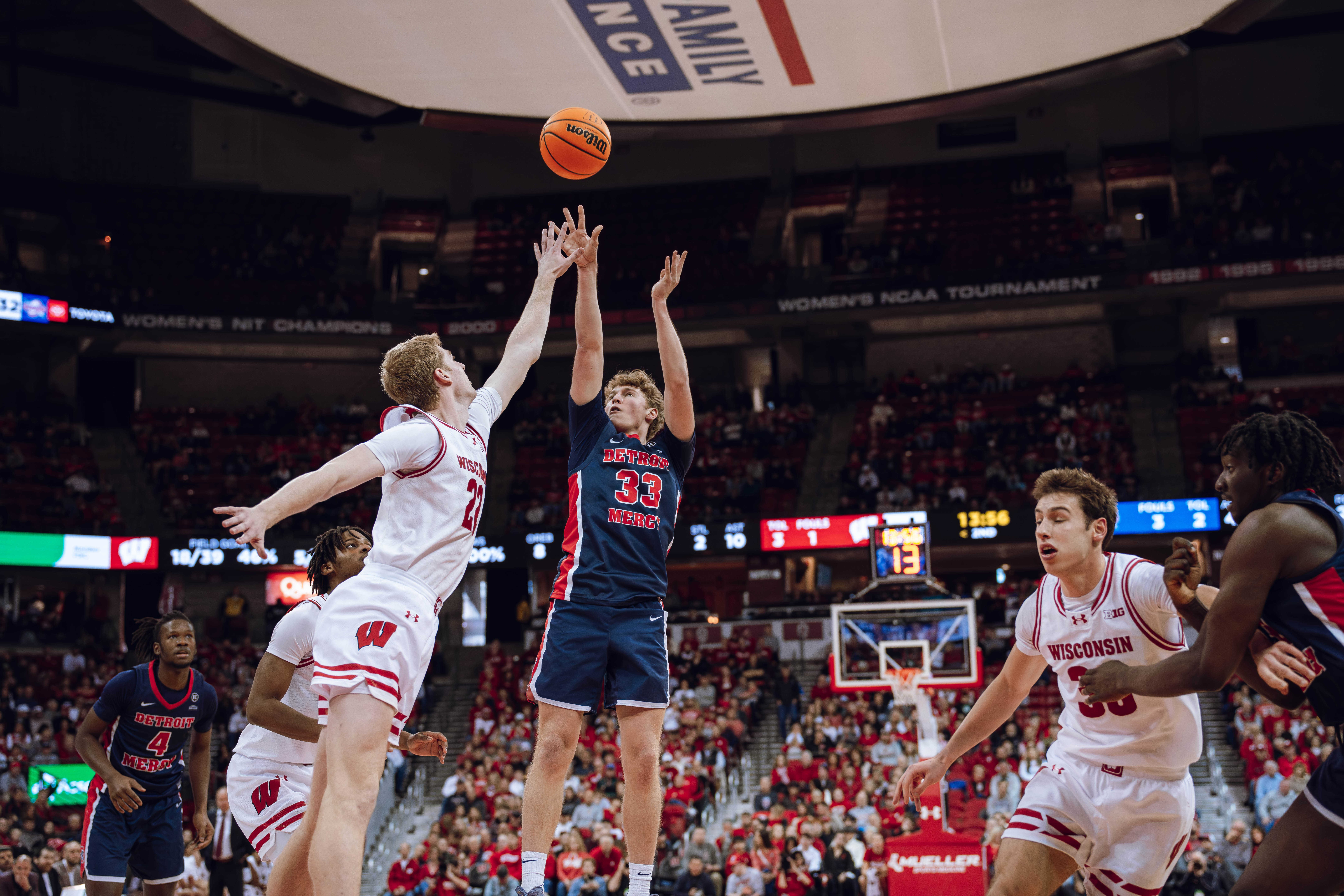 Detroit Mercy Titans guard TJ Nadeau #33 attempts a jump shot over Wisconsin Badgers forward Steven Crowl #22 at Kohl Center on December 22, 2024 in Madison, Wisconsin. Photography by Ross Harried for Second Crop Sports.