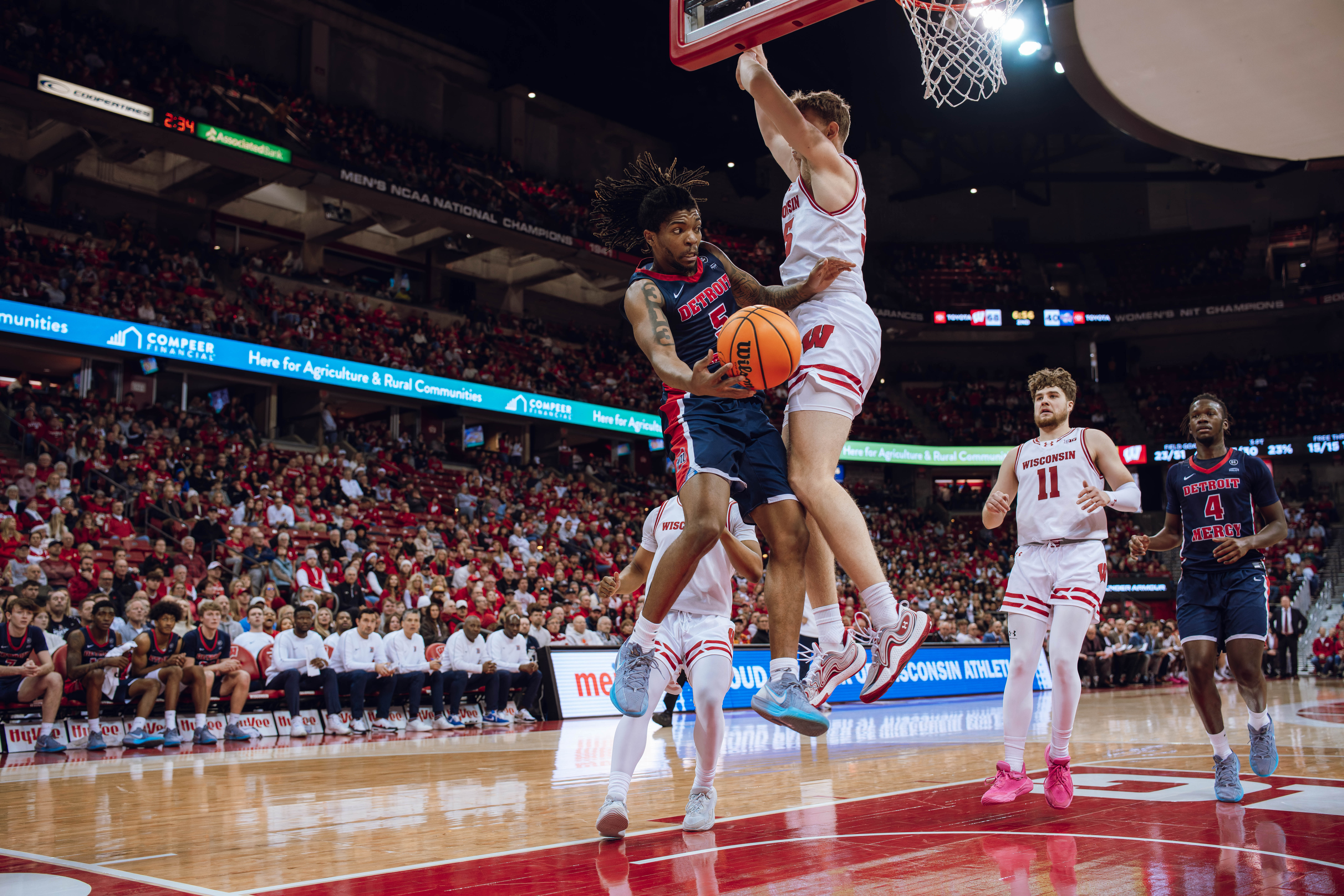 Detroit Mercy Titans guard Orlando Lovejoy #5 passes the ball under the hoop against the Wisconsin Badgers at Kohl Center on December 22, 2024 in Madison, Wisconsin. Photography by Ross Harried for Second Crop Sports.