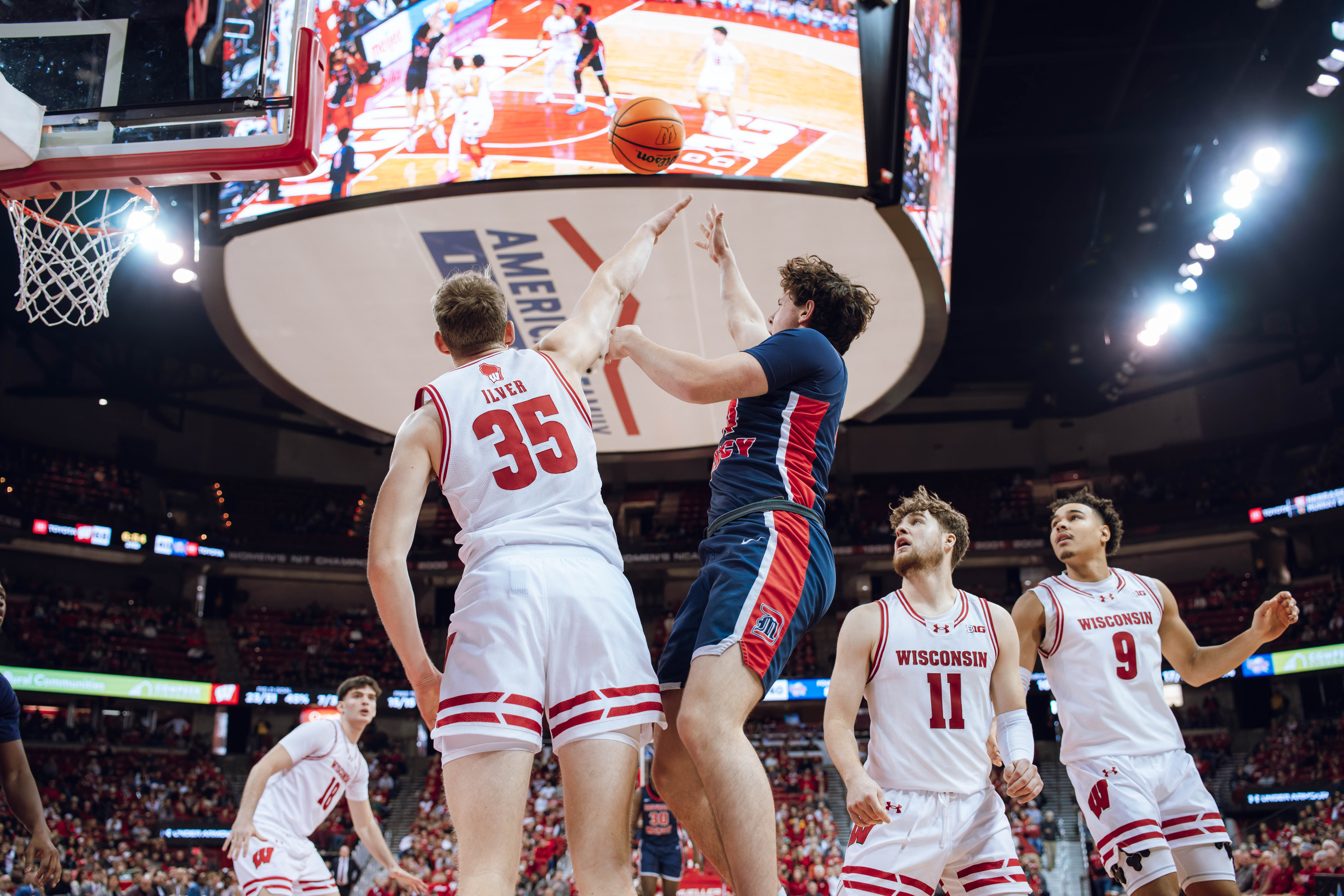 Detroit Mercy Titans guard Peter Fuchs Jr. #14 attempts a shot over Wisconsin Badgers forward Markus Ilver #35 at Kohl Center on December 22, 2024 in Madison, Wisconsin. Photography by Ross Harried for Second Crop Sports.