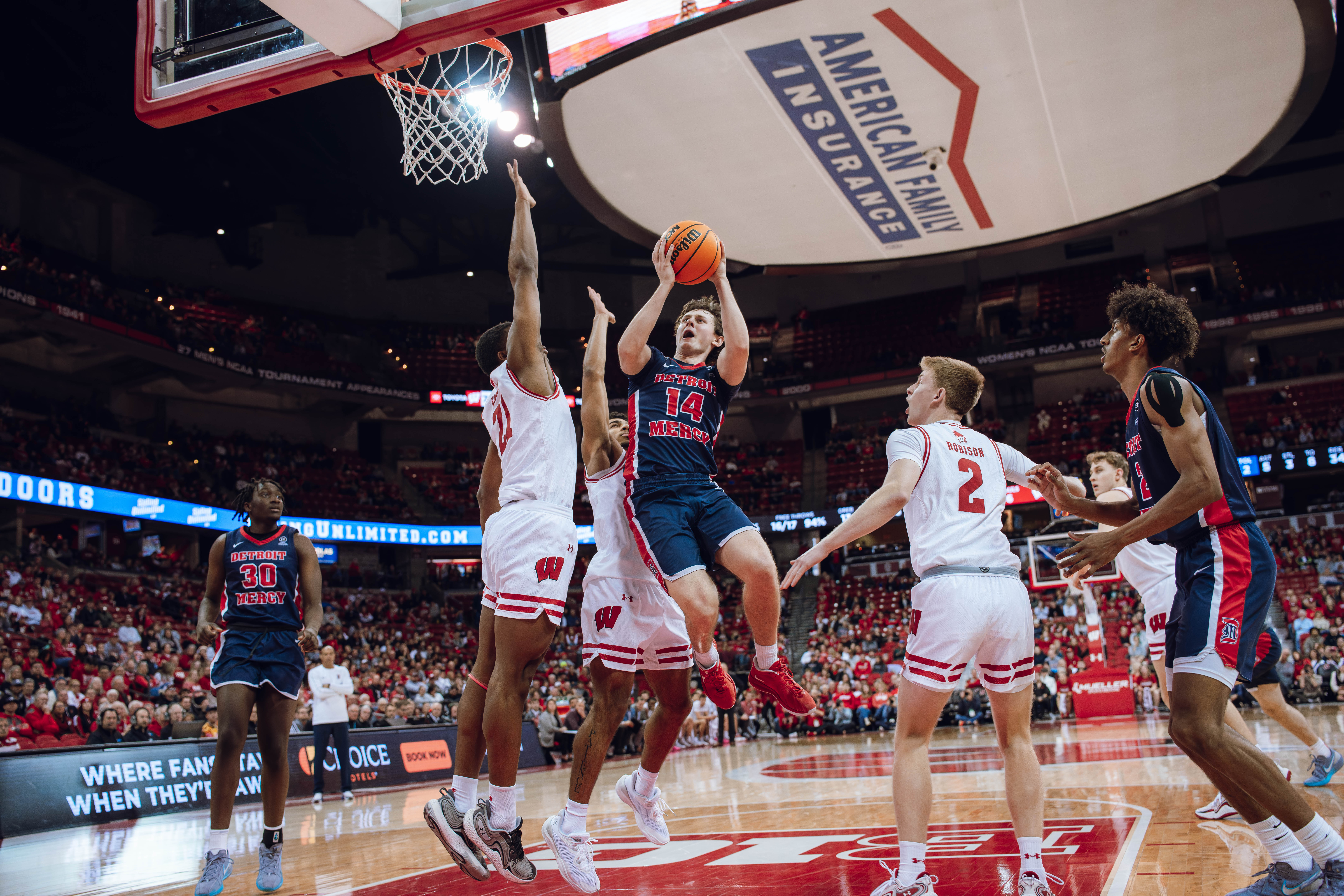 Detroit Mercy Titans guard Peter Fuchs Jr. #14 drives the lane against the Wisconsin Badgers at Kohl Center on December 22, 2024 in Madison, Wisconsin. Photography by Ross Harried for Second Crop Sports.