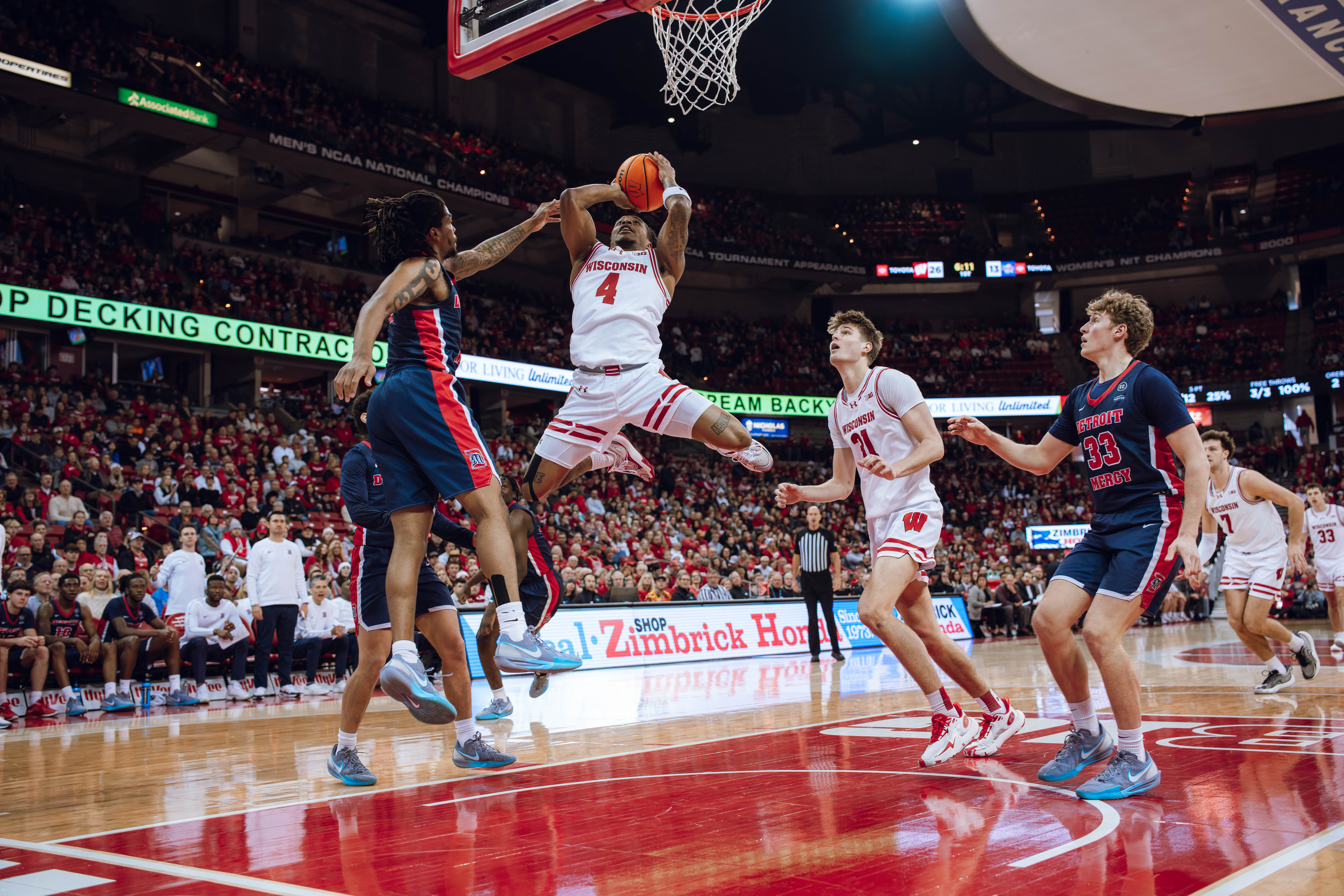 Wisconsin Badgers guard Kamari McGee #4 skies for the rebound and layup agains the Detroit Mercy Titans at Kohl Center on December 22, 2024 in Madison, Wisconsin. Photography by Ross Harried for Second Crop Sports.