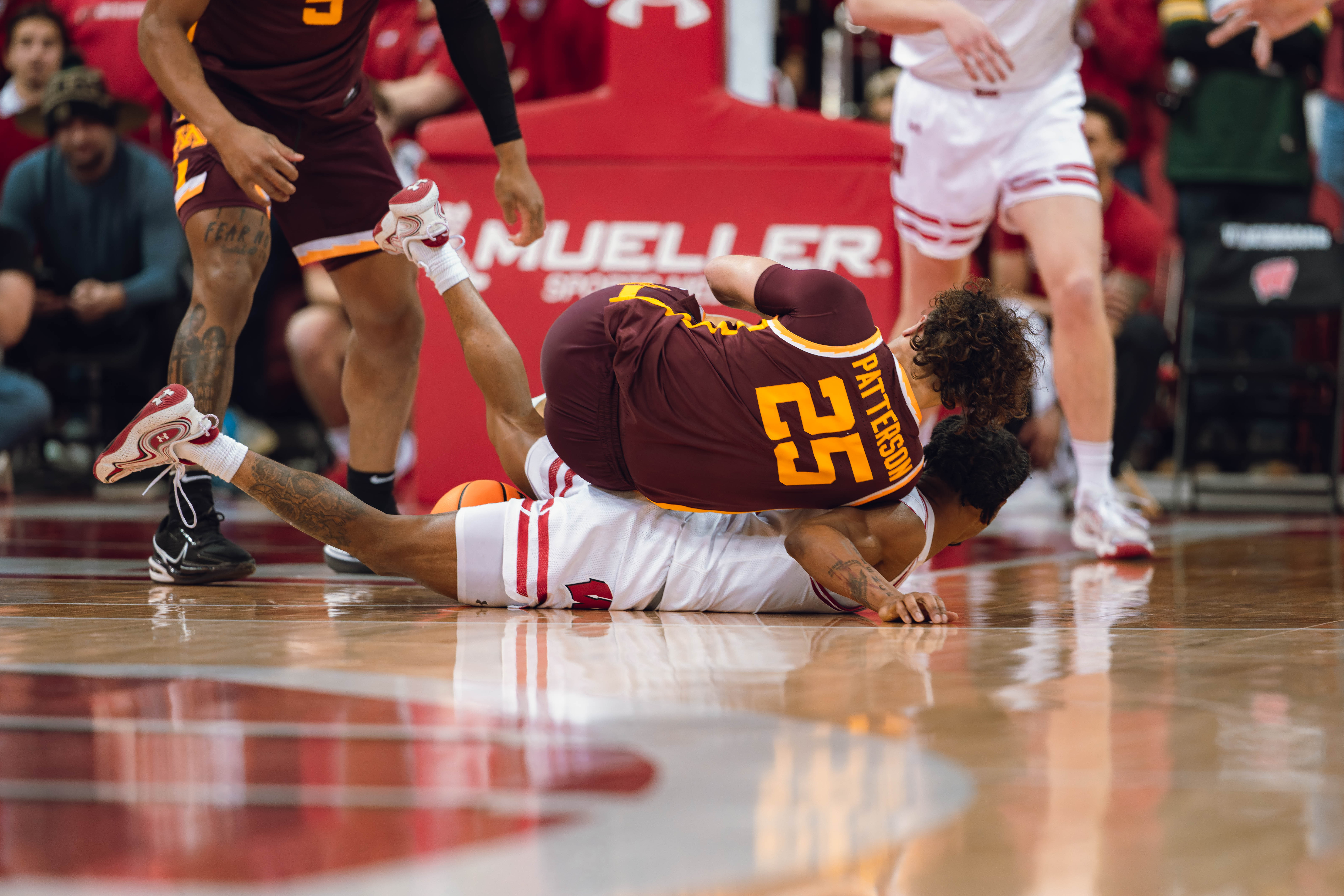 Minnesota Golden Gophers guard Lu'Cye Patterson #25 rolls over Wisconsin Badgers guard Kamari McGee #4 for a loose ball at Kohl Center on January 10, 2025 in Madison, Wisconsin. Photography by Ross Harried for Second Crop Sports.