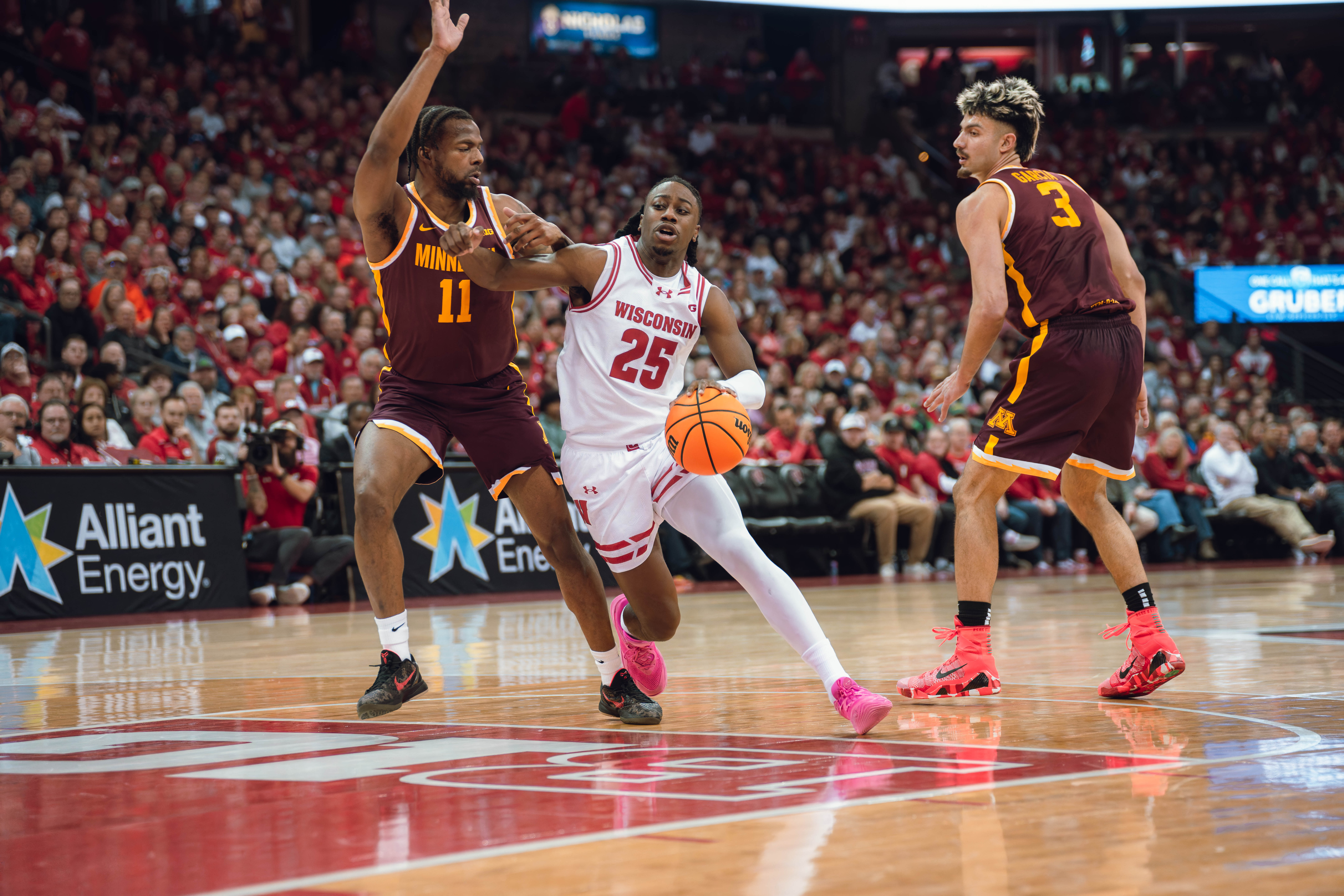 Wisconsin Badgers guard John Blackwell #25 drives the lane defended by Minnesota Golden Gophers guard Femi Odukale #11 at Kohl Center on January 10, 2025 in Madison, Wisconsin. Photography by Ross Harried for Second Crop Sports.