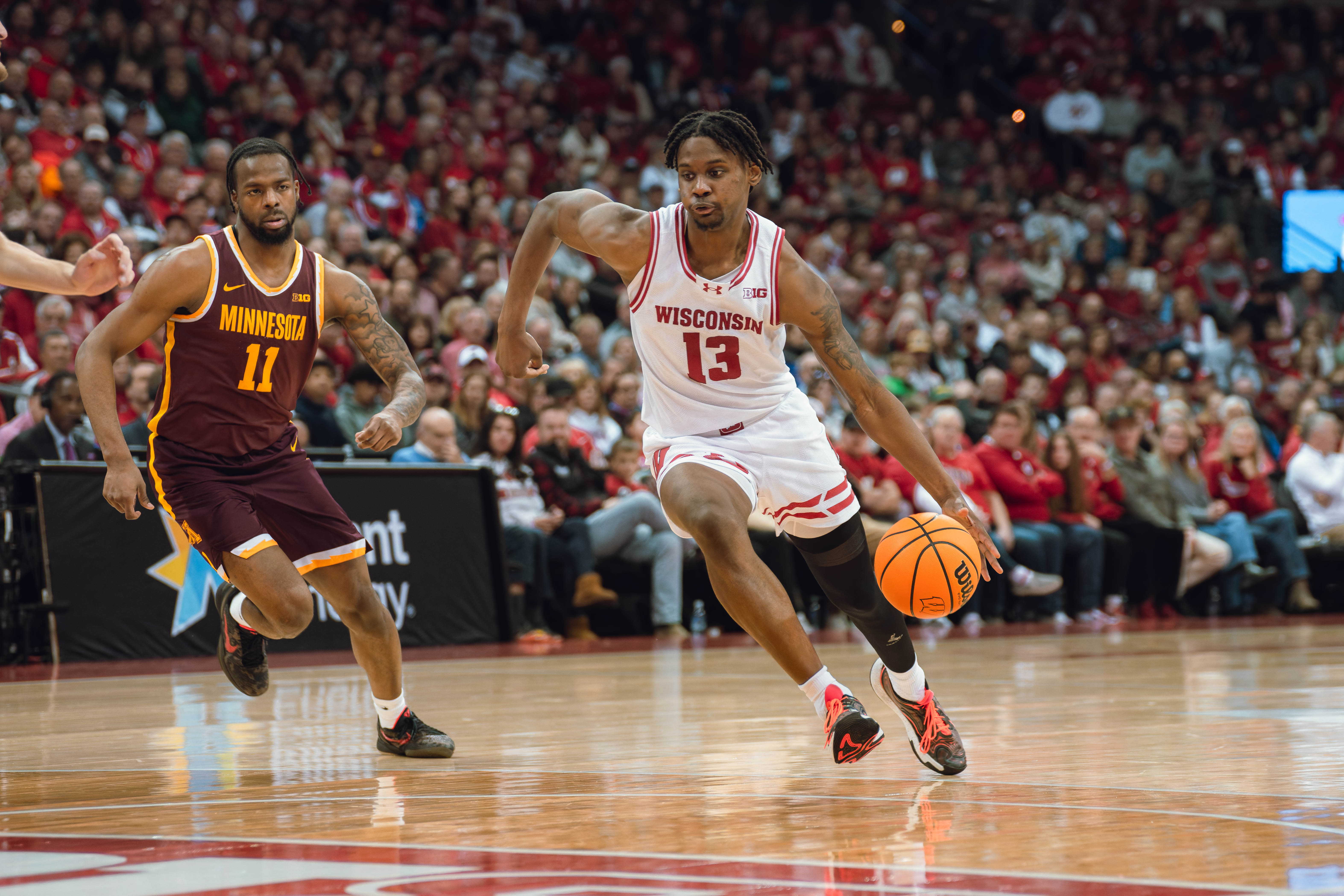 Wisconsin Badgers forward Xavier Amos #13 drives past Minnesota Golden Gophers guard Femi Odukale #11 at Kohl Center on January 10, 2025 in Madison, Wisconsin. Photography by Ross Harried for Second Crop Sports.