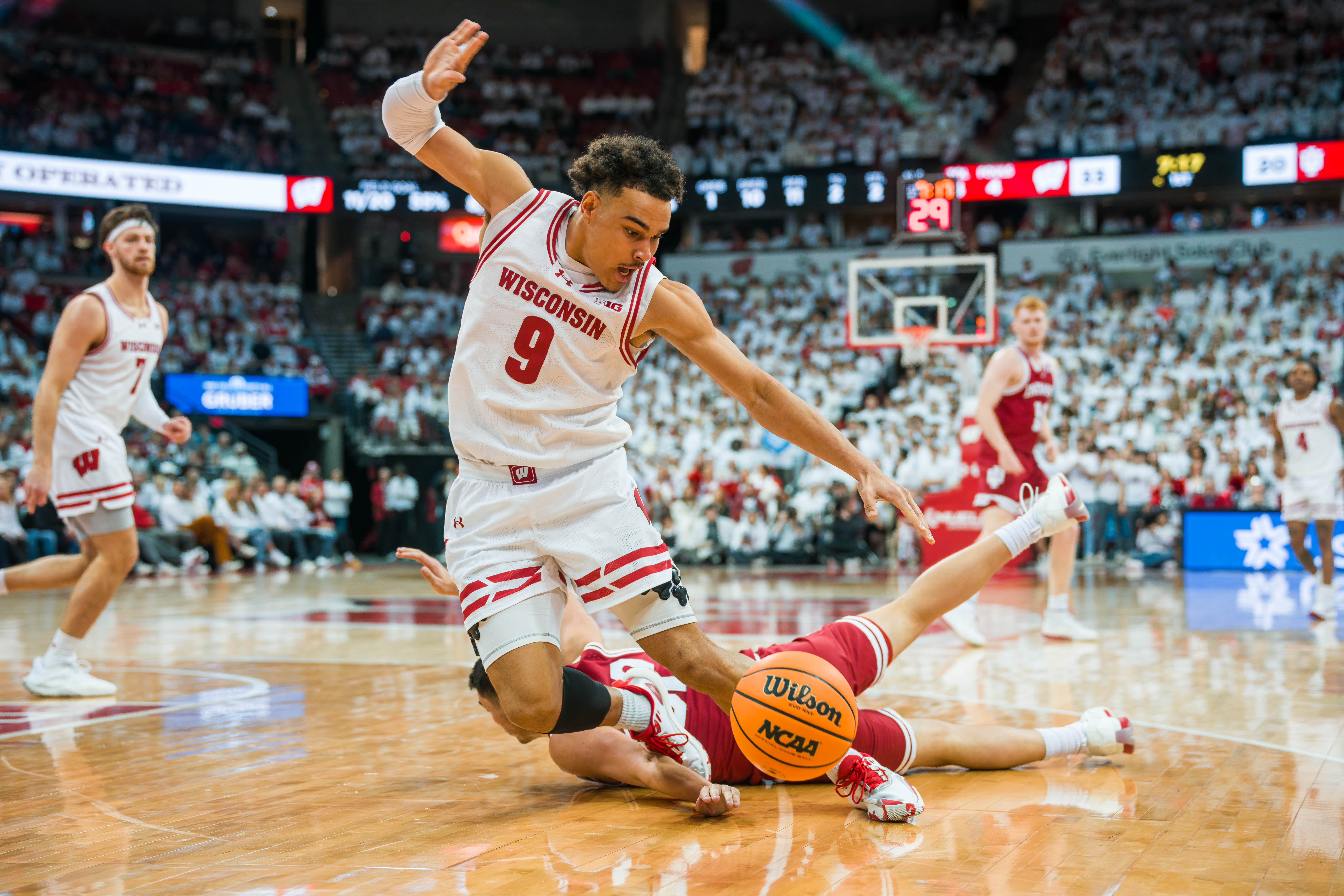 Wisconsin Badgers guard John Tonje #9 gets tripped up chasing a loose ball by Indiana Hoosiers Guard Trey Galloway #32 at the Kohl Center on February 04, 2025 in Madison, Wisconsin. Photography by Ross Harried for Second Crop Sports.