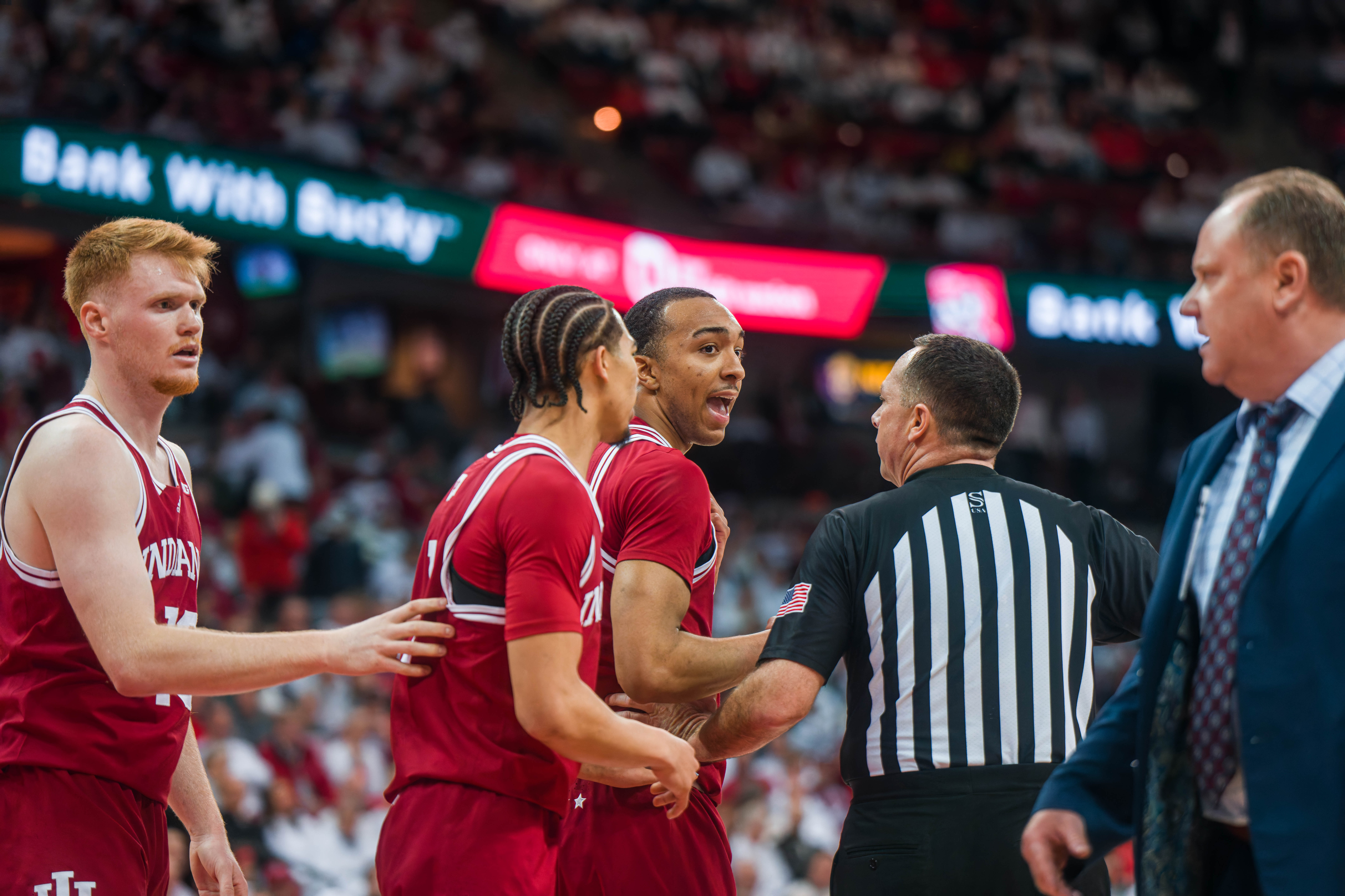 Indiana Hoosiers Forward Bryson Tucker #8 tries to explain his hard foul to a referee as Wisconsin Badgers Head Coach Greg Gard looks on at the Kohl Center on February 04, 2025 in Madison, Wisconsin. Photography by Ross Harried for Second Crop Sports.