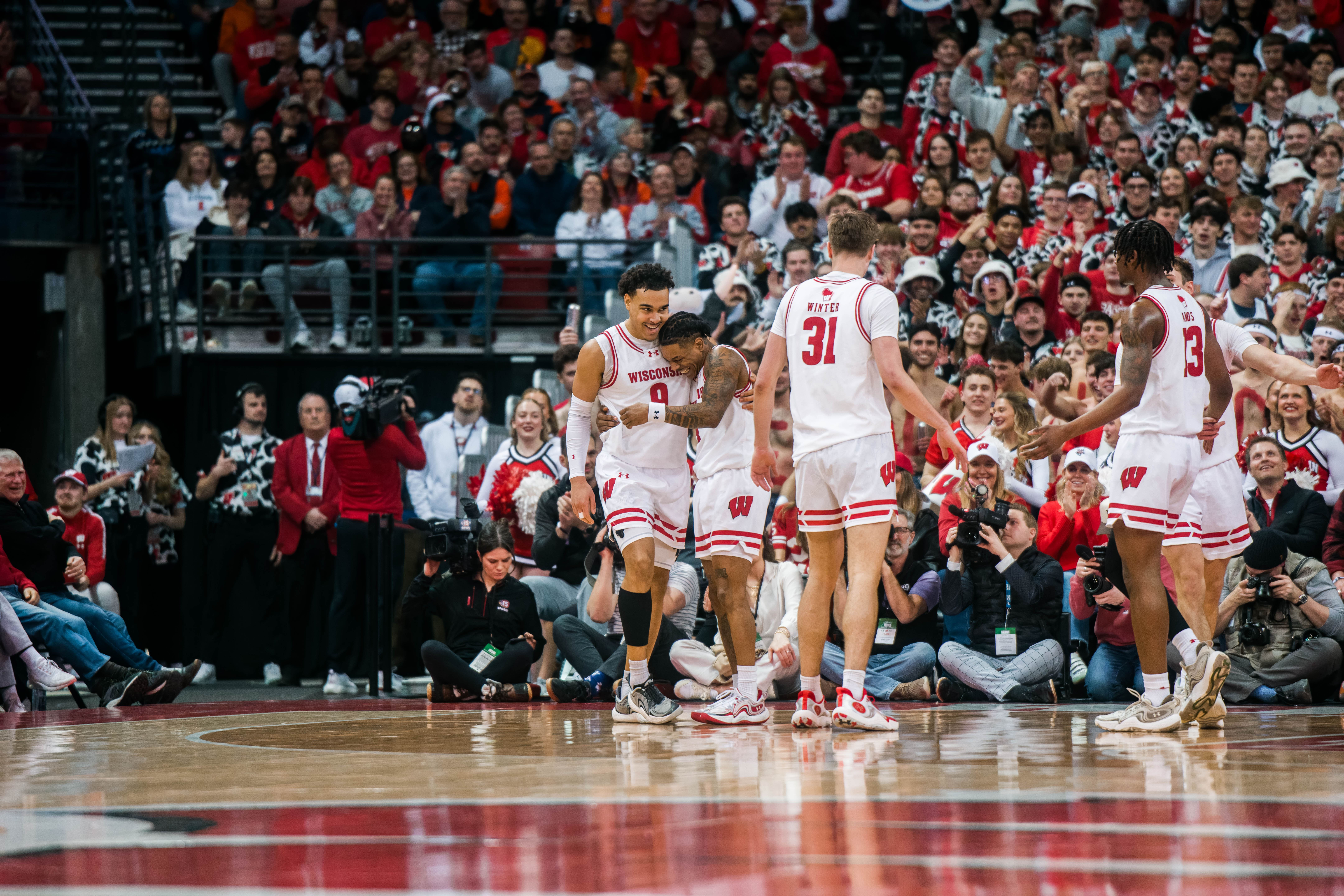 Wisconsin Badgers guard John Tonje #9 embraces Badgers guard Kamari McGee #4 against the Illinois Fighting Illini at The Kohl Center on February 18, 2025 in Madison, Wisconsin. Photography by Ross Harried for Second Crop Sports.