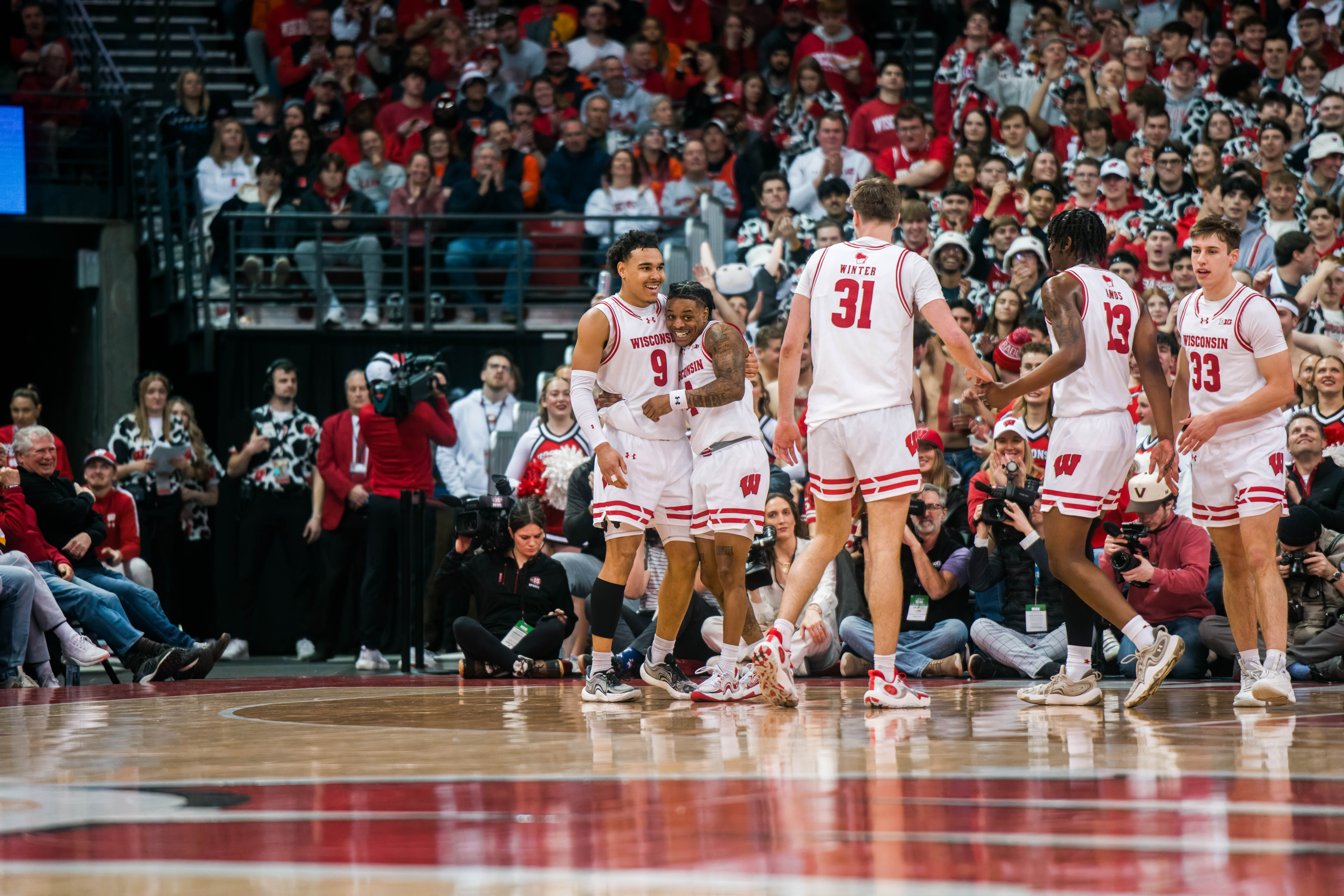 Wisconsin Badgers guard John Tonje #9 embraces Badgers guard Kamari McGee #4 against the Illinois Fighting Illini at The Kohl Center on February 18, 2025 in Madison, Wisconsin. Photography by Ross Harried for Second Crop Sports.