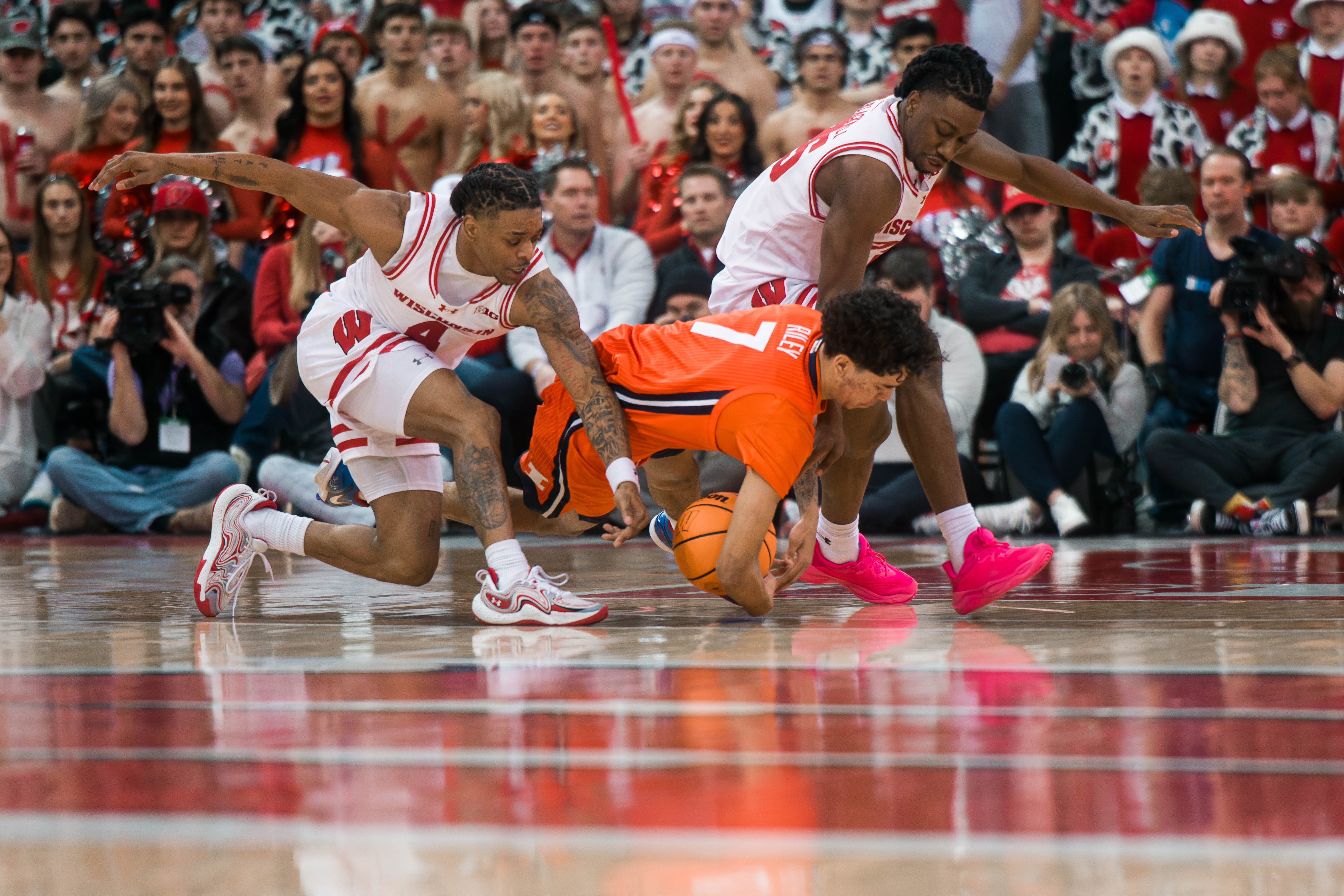 Wisconsin Badgers guard Kamari McGee #4, John Blackwell #25 & Illinois Fighting Illini forward Will Riley #7 dive for a loose ball at The Kohl Center on February 18, 2025 in Madison, Wisconsin. Photography by Ross Harried for Second Crop Sports.