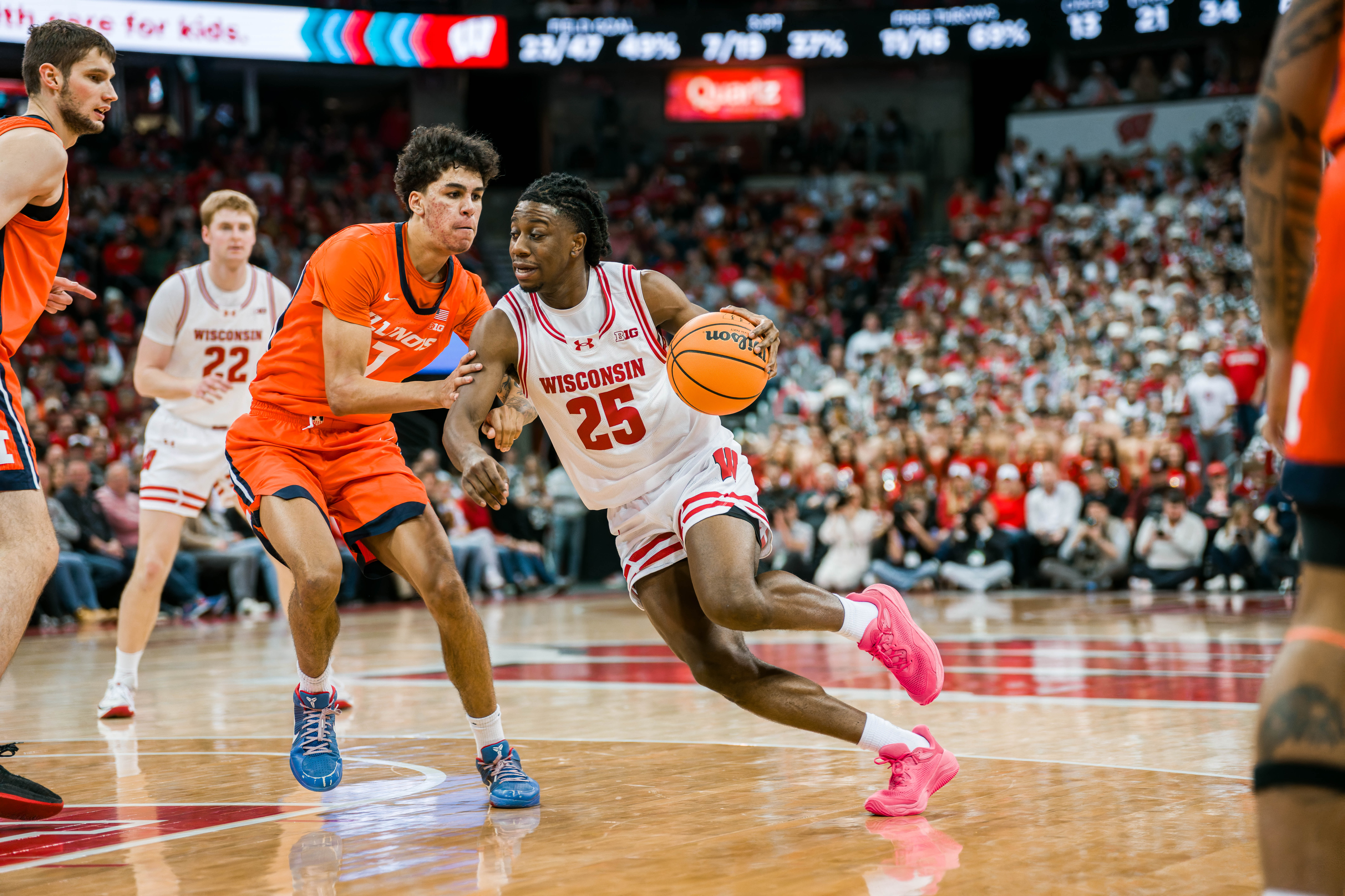 Wisconsin Badgers guard John Blackwell #25 drives the lane while defended by Illinois Fighting Illini forward Will Riley #7 at The Kohl Center on February 18, 2025 in Madison, Wisconsin. Photography by Ross Harried for Second Crop Sports.