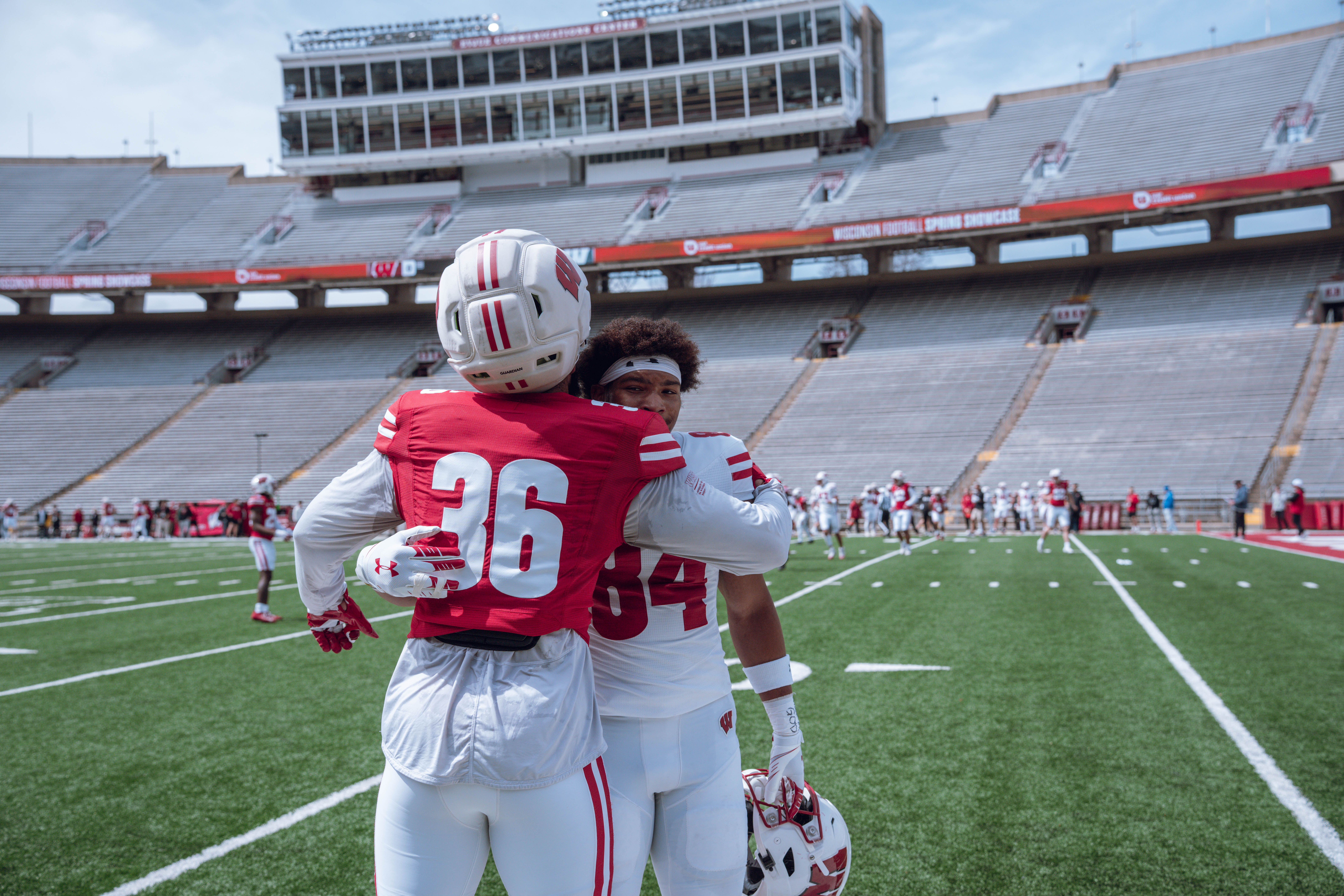 Wisconsin Badgers wide receiver Chris Brooks Jr. #84 gives Badgers outside linebacker Angel Toombs #36 a hug before the Wisconsin Football Spring Showcase at Camp Randall Stadium on April 19, 2025 in Madison, Wisconsin. Photography by Ross Harried for Second Crop Sports.