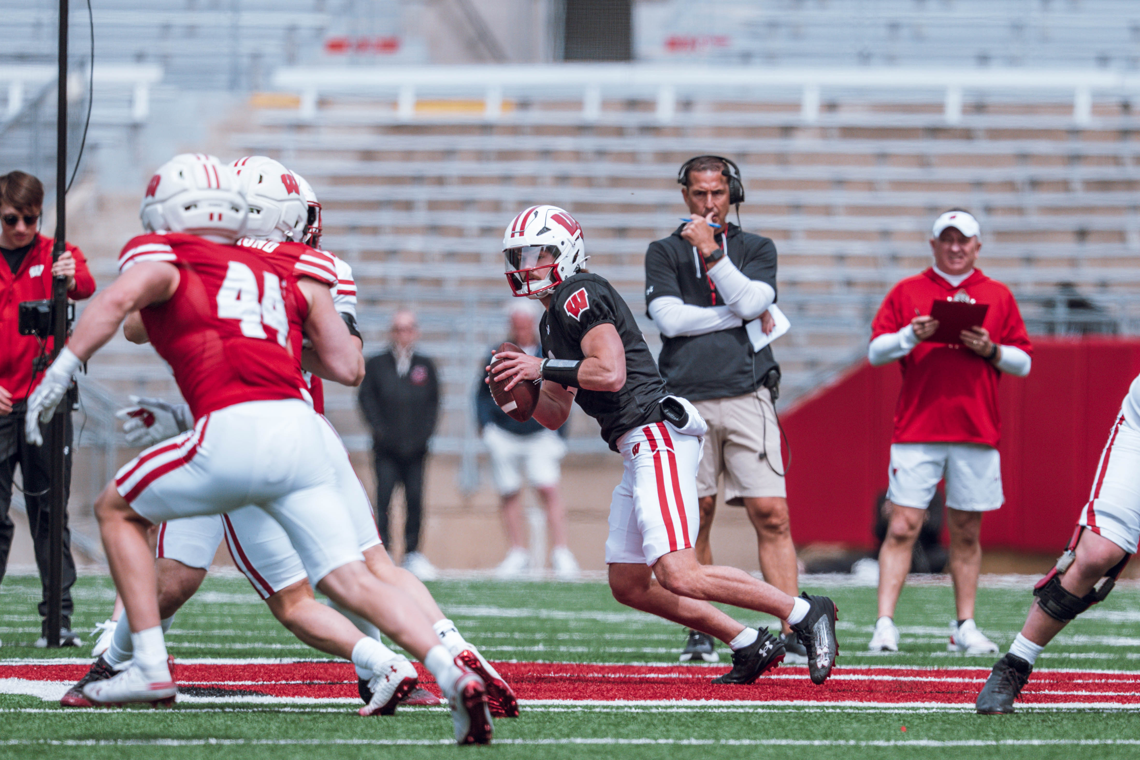 Wisconsin Badgers quarterback Carter Smith #3 rolls out to his right while head coach Luke Fickell looks on during the Wisconsin Football Spring Showcase at Camp Randall Stadium on April 19, 2025 in Madison, Wisconsin. Photography by Ross Harried for Second Crop Sports.