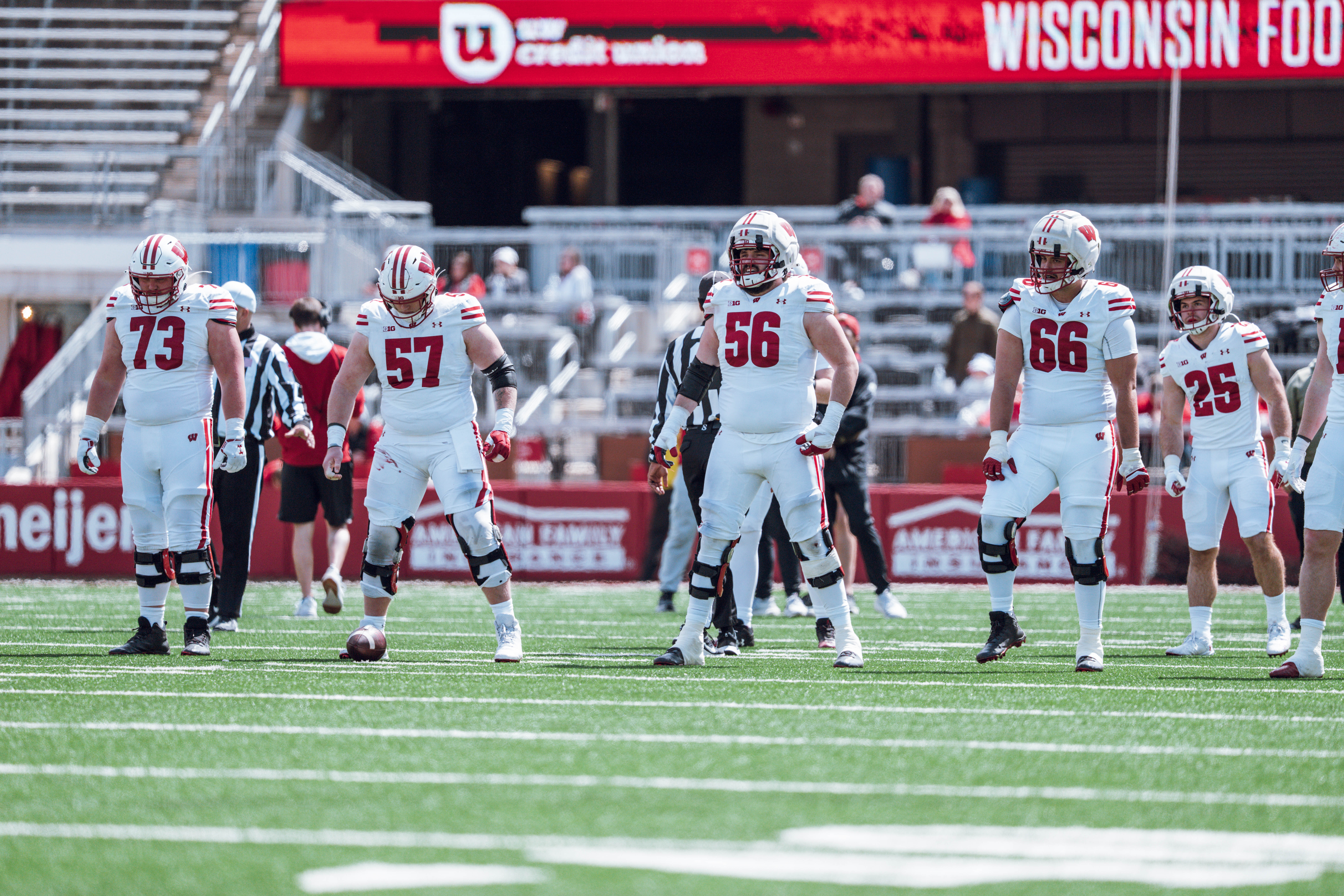 Wisconsin Badgers offensive lineman Kerry Kodanko #73, Jake Renfro #57, Joe Brunner #56, Leyton Nelson #66 and running back Cade Yacamelli #25 line up before a play during the Wisconsin Football Spring Showcase at Camp Randall Stadium on April 19, 2025 in Madison, Wisconsin. Photography by Ross Harried for Second Crop Sports.