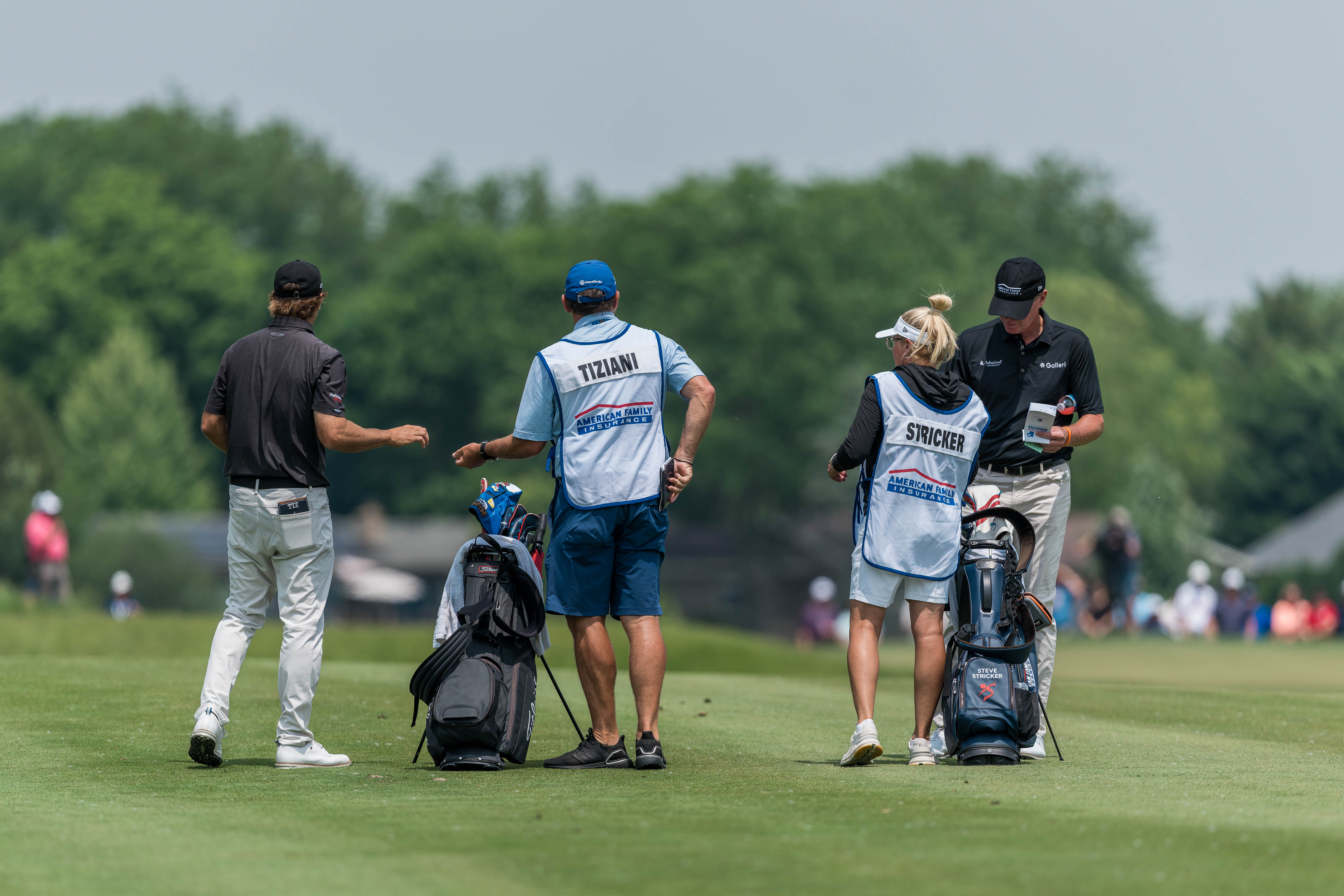 Mario Tiziani (left) & Steve Stricker (right) consult their caddies during round 2 of The American Family Insurance Championship at TPC Wisconsin in Madison, Wisconsin on June 7th, 2025. Photography by Ross Harried for Second Crop Sports.