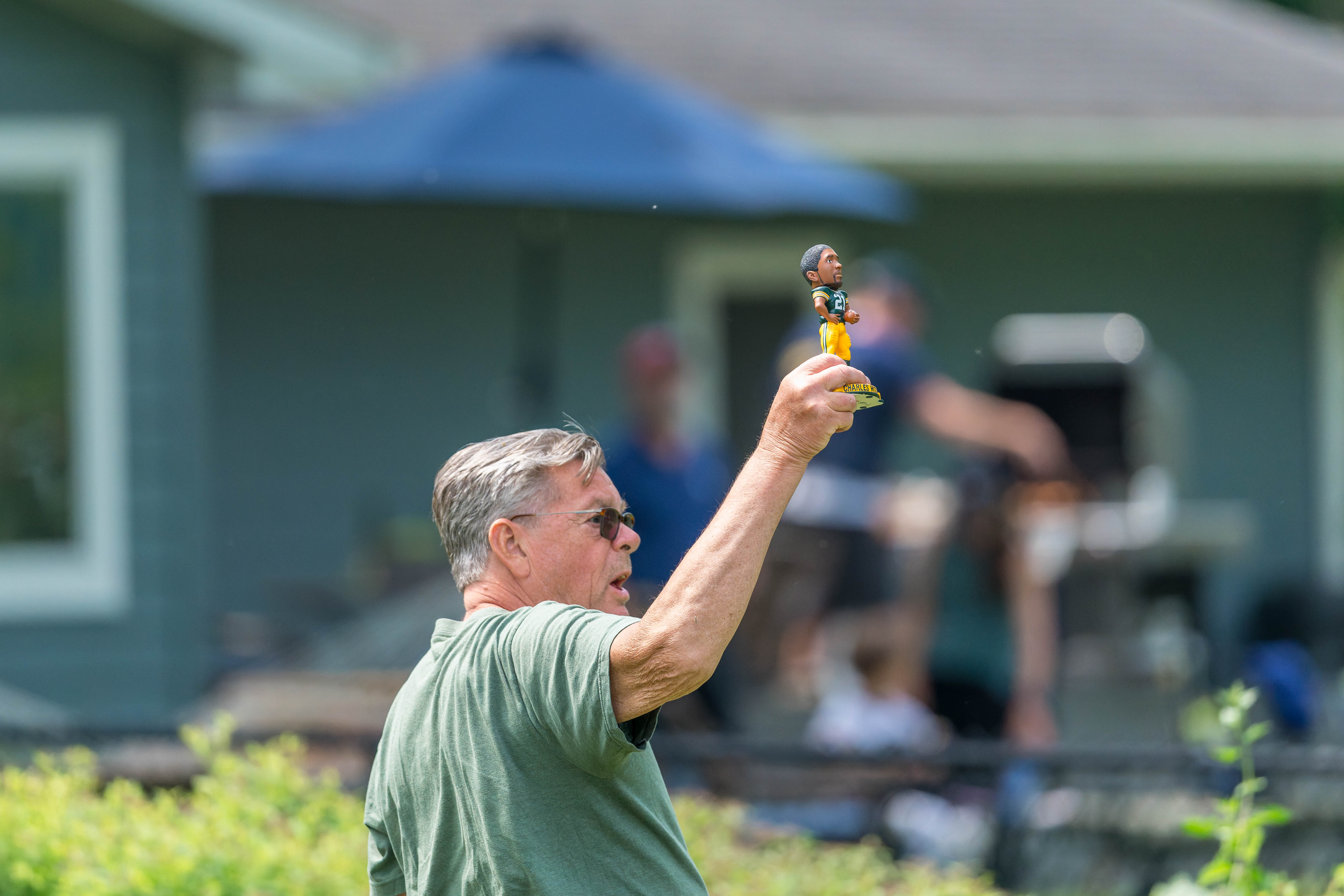 A spectator holds up a Charles Woodson bobblehead on hole 12 during round 2 of The American Family Insurance Championship at TPC Wisconsin in Madison, Wisconsin on June 7th, 2025. Photography by Ross Harried for Second Crop Sports.