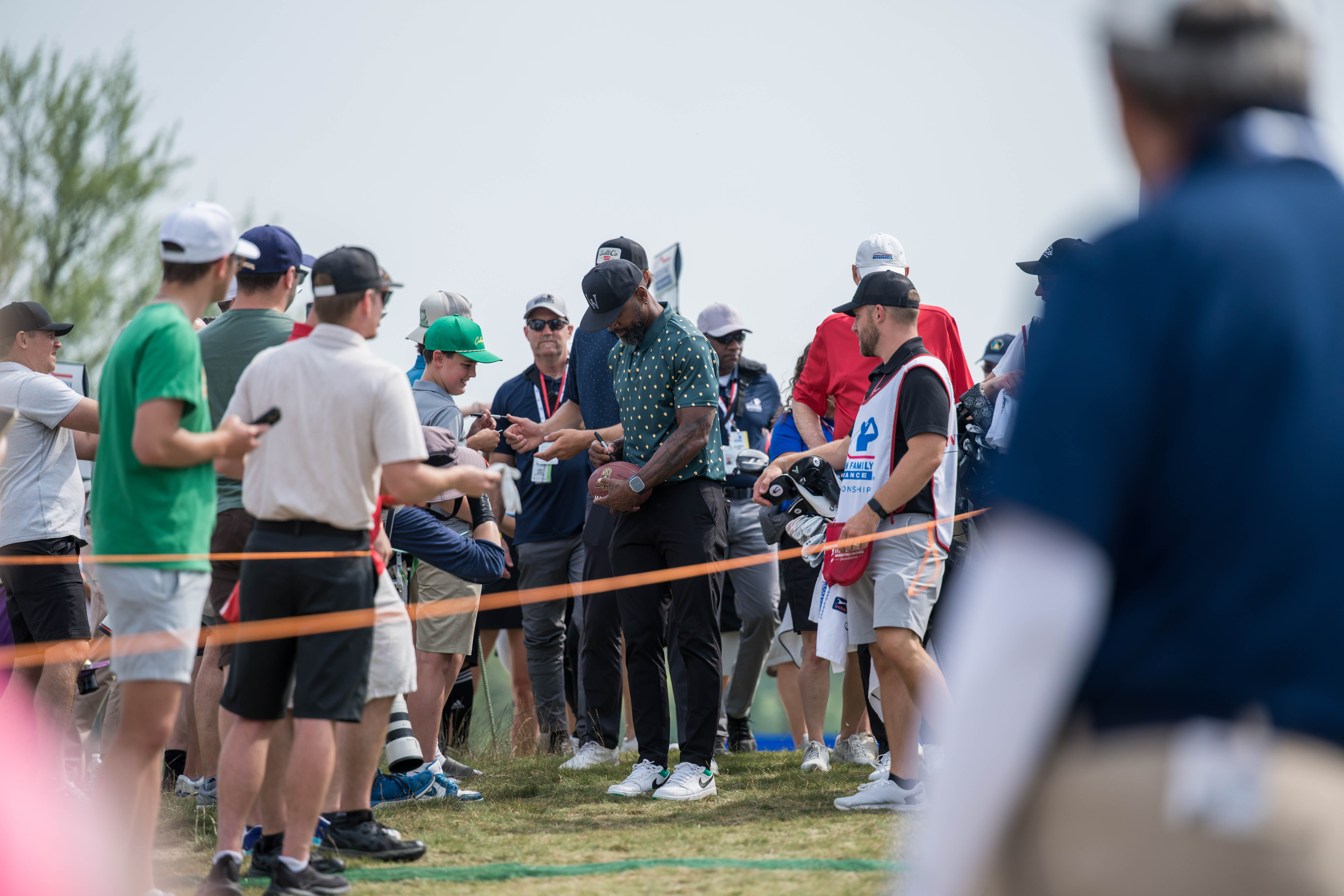 Charles Woodson signs a football for a fan during round 2 of The American Family Insurance Championship at TPC Wisconsin in Madison, Wisconsin on June 7th, 2025. Photography by Ross Harried for Second Crop Sports.