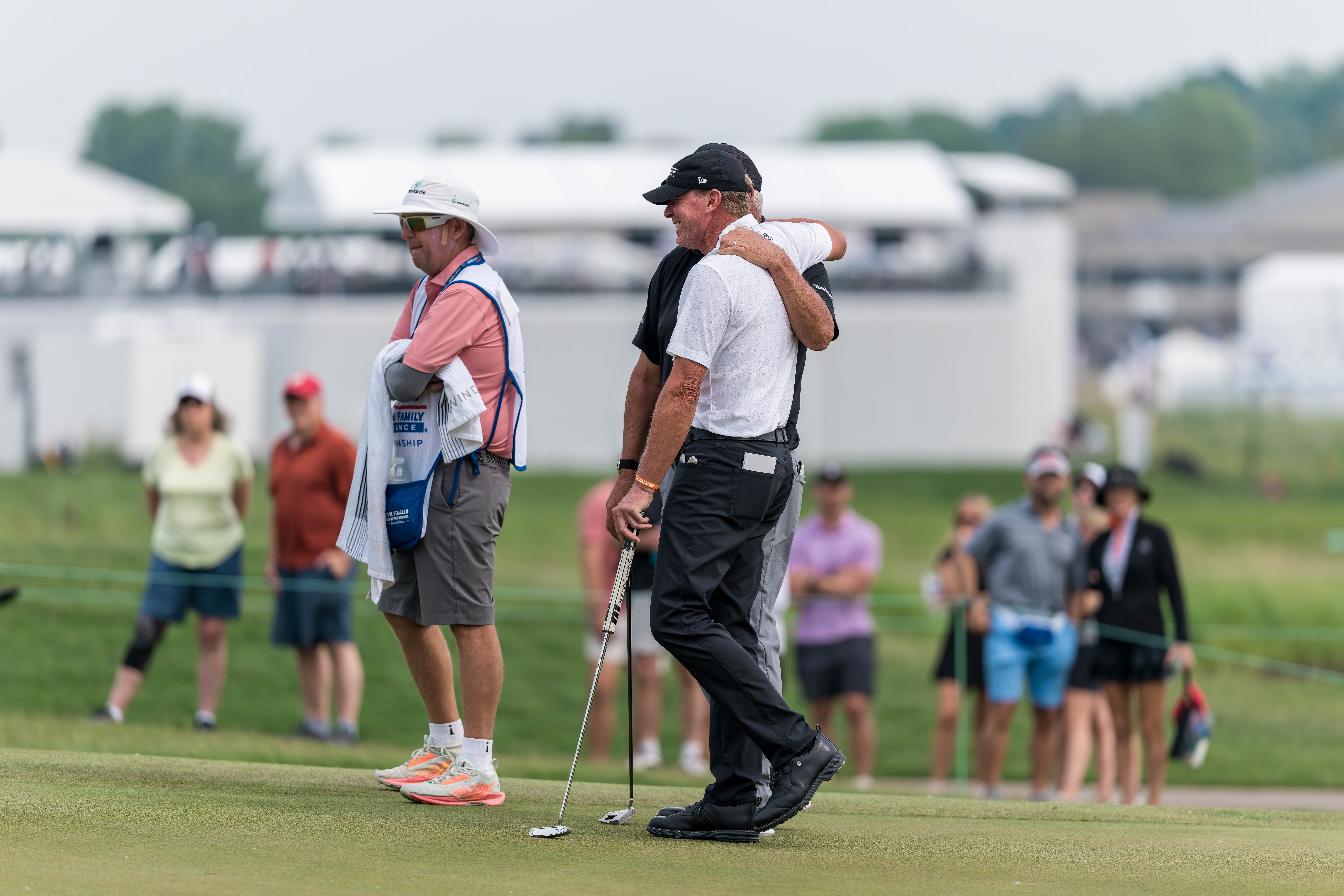 Darren Clarke (back), and Steve Stricker (front) embrace on hole 13 during round 3 of The American Family Insurance Championship at TPC Wisconsin in Madison, Wisconsin on June 8th, 2025. Photography by Ross Harried for Second Crop Sports.