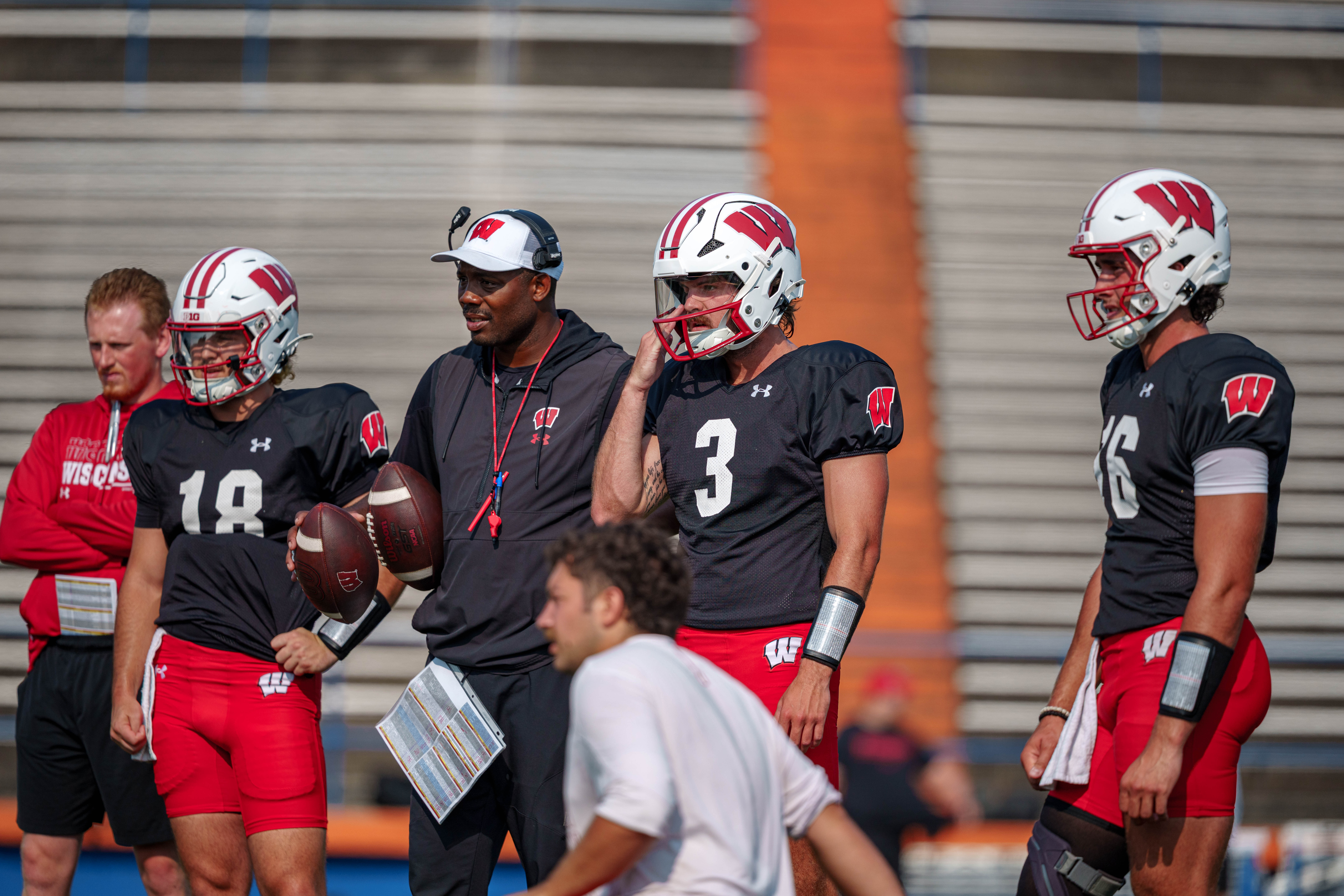The Wisconsin Badgers quarterbacks Danny O'Neil (18), Carter Smith (3), Milos Spasojevic (16) during training camp at Ralph E. Davis Pioneer Stadium on August 03, 2025 in Platteville, Wisconsin. Photography by Ross Harried for Second Crop Sports.