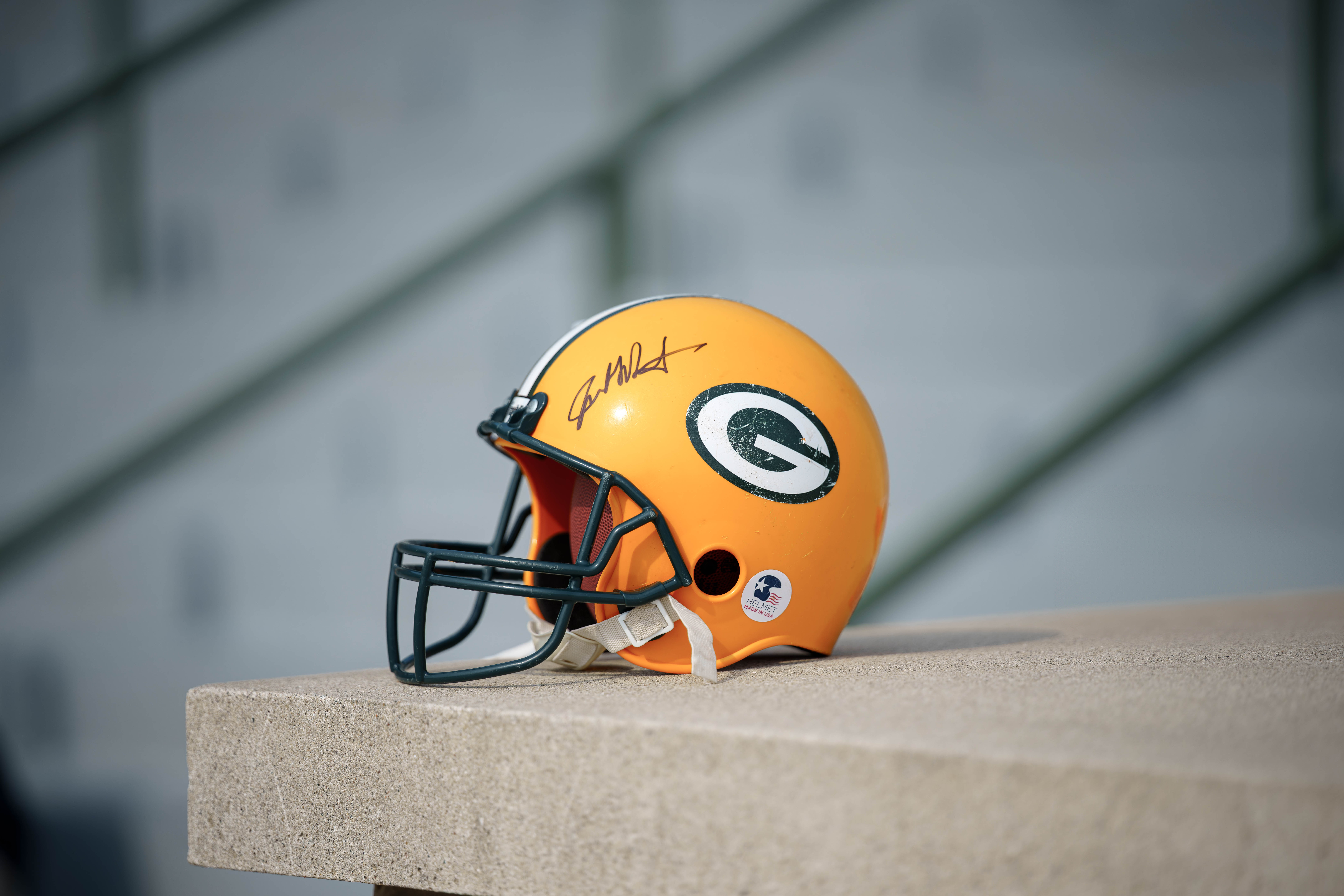 A Green Bay Packers helmet with a player autograph rests outside Lambeau Field before training camp practice in Green Bay, Wisconsin, on August 6th, 2025. Photography by Ross Harried for Second Crop Sports.