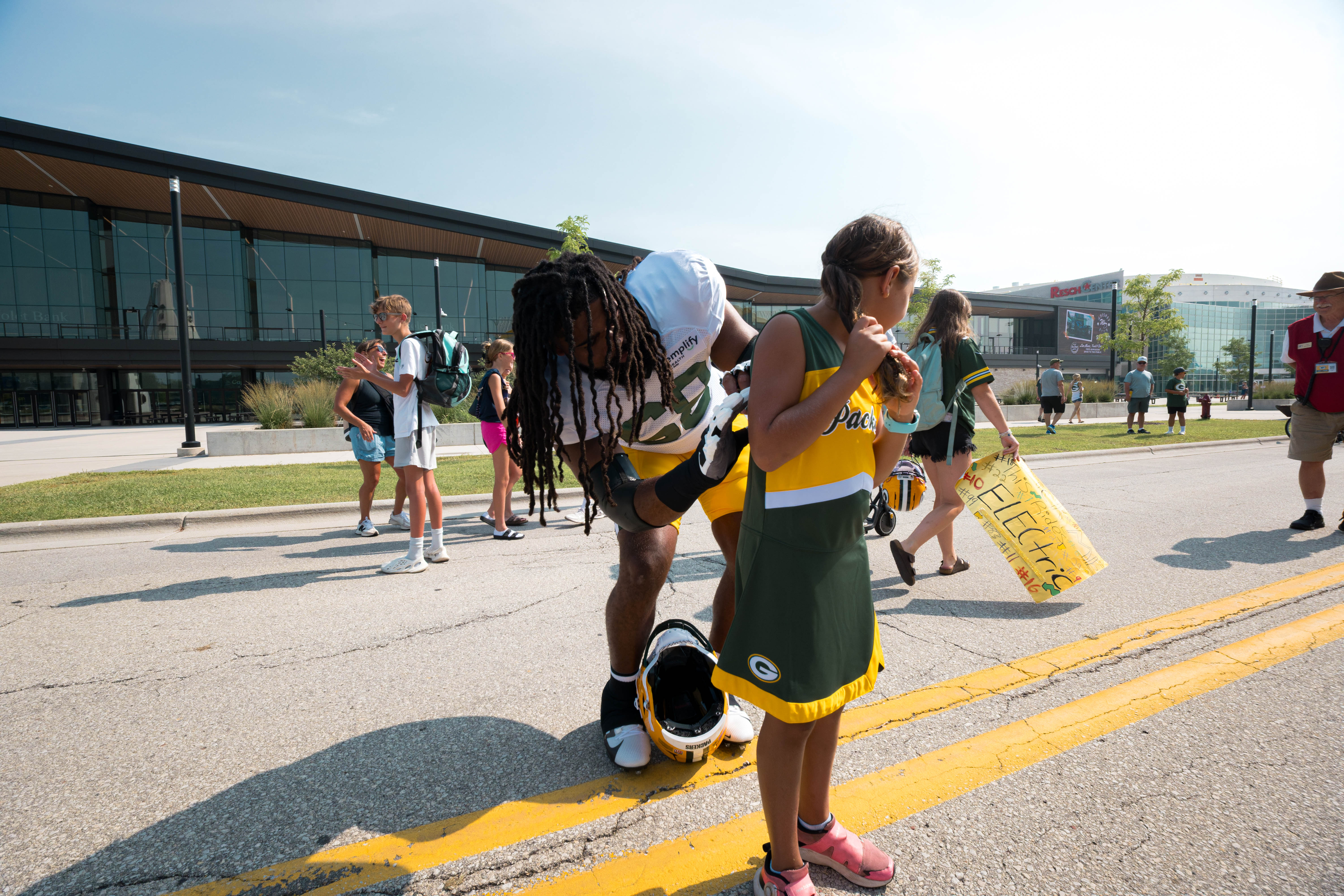 Green Bay Packers offensive lineman, Lecitus Smith signs the uniform of a young cheerleader during training camp in Green Bay, Wisconsin, on August 6th, 2025. Photography by Ross Harried for Second Crop Sports.