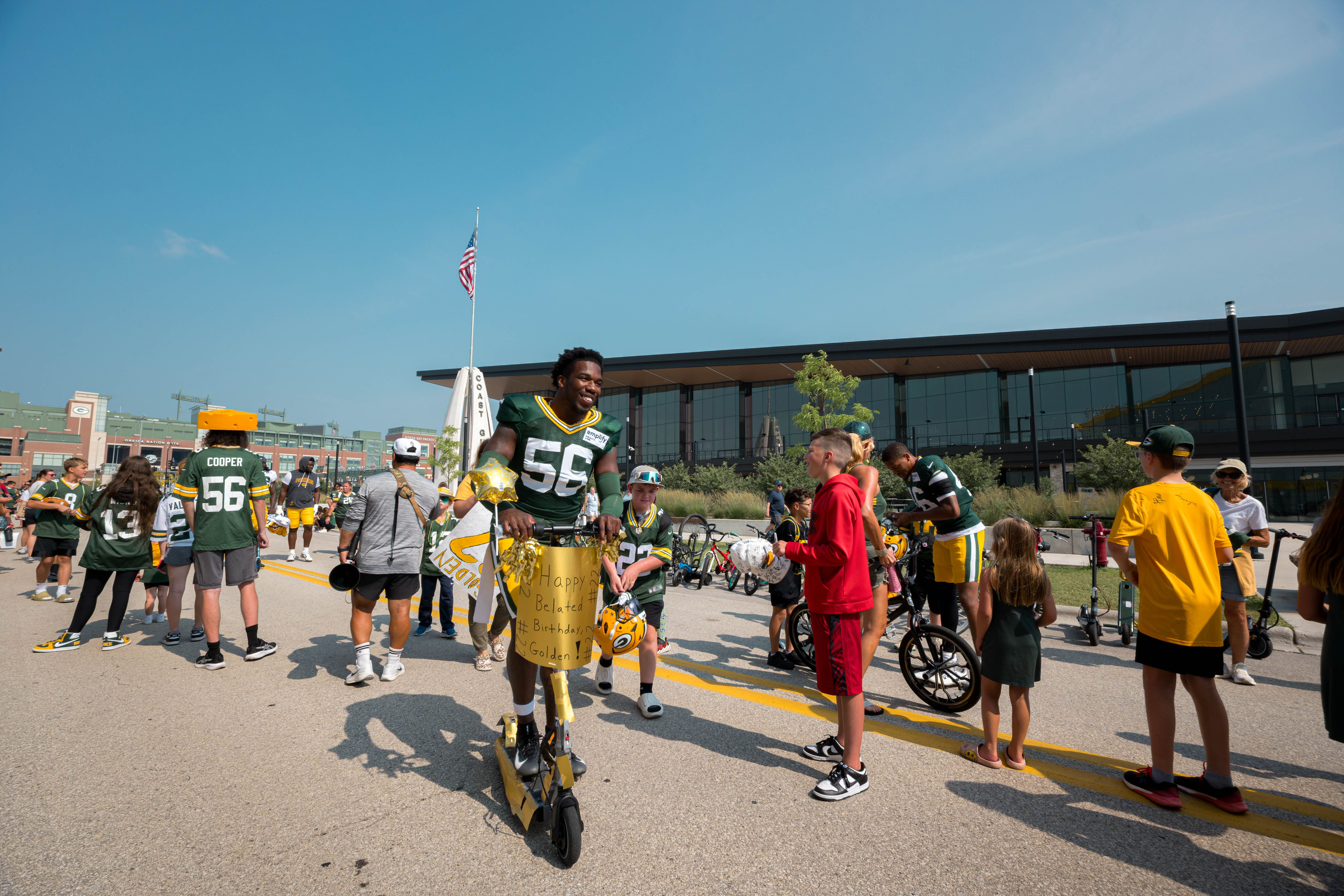 Green Bay Packers linebacker Edgerrin Cooper (56) rides a scooter with fans during the DreamDrive tradition at training camp in Green Bay, Wisconsin, on August 6th, 2025. Photography by Ross Harried for Second Crop Sports.