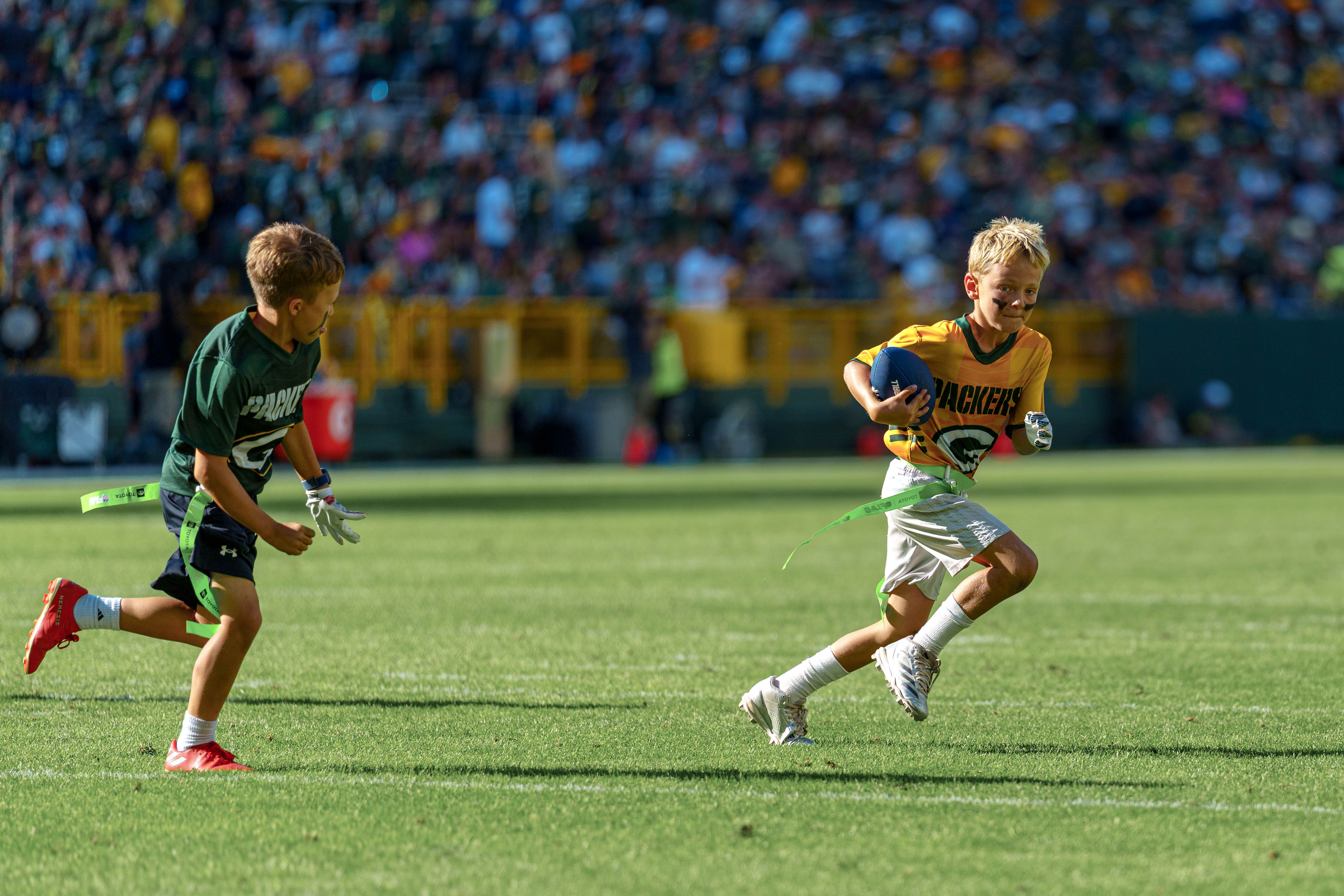 The Verona Area flag football team takes the field during halftime of an NFL preseason game between the Green Bay Packers and Seattle Seahawks at Lambeau Field in Green Bay, Wisconsin, on August 23, 2025. Photography by Ross Harried for Second Crop Sports.