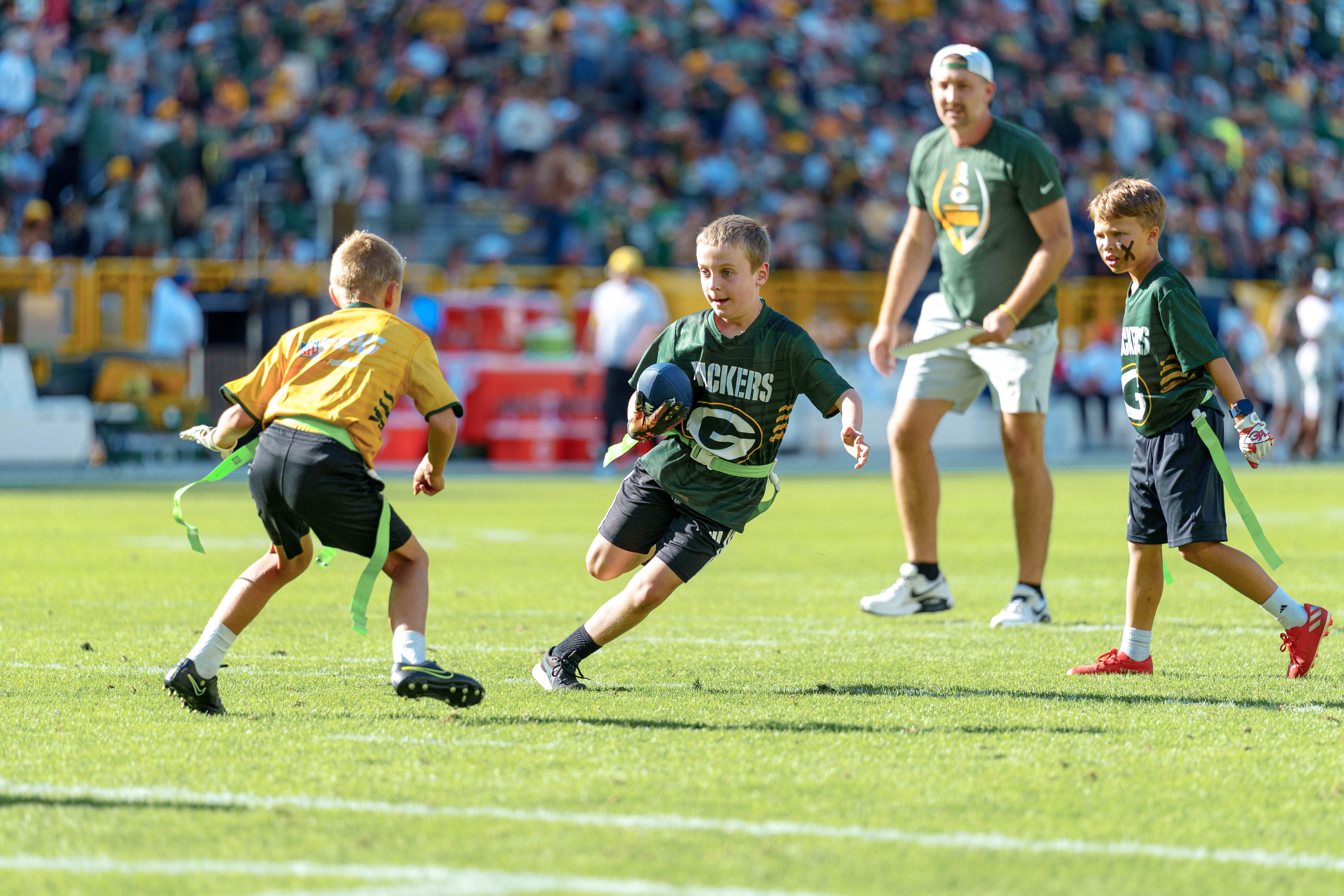 The Verona Area flag football team takes the field during halftime of an NFL preseason game between the Green Bay Packers and Seattle Seahawks at Lambeau Field in Green Bay, Wisconsin, on August 23, 2025. Photography by Ross Harried for Second Crop Sports.